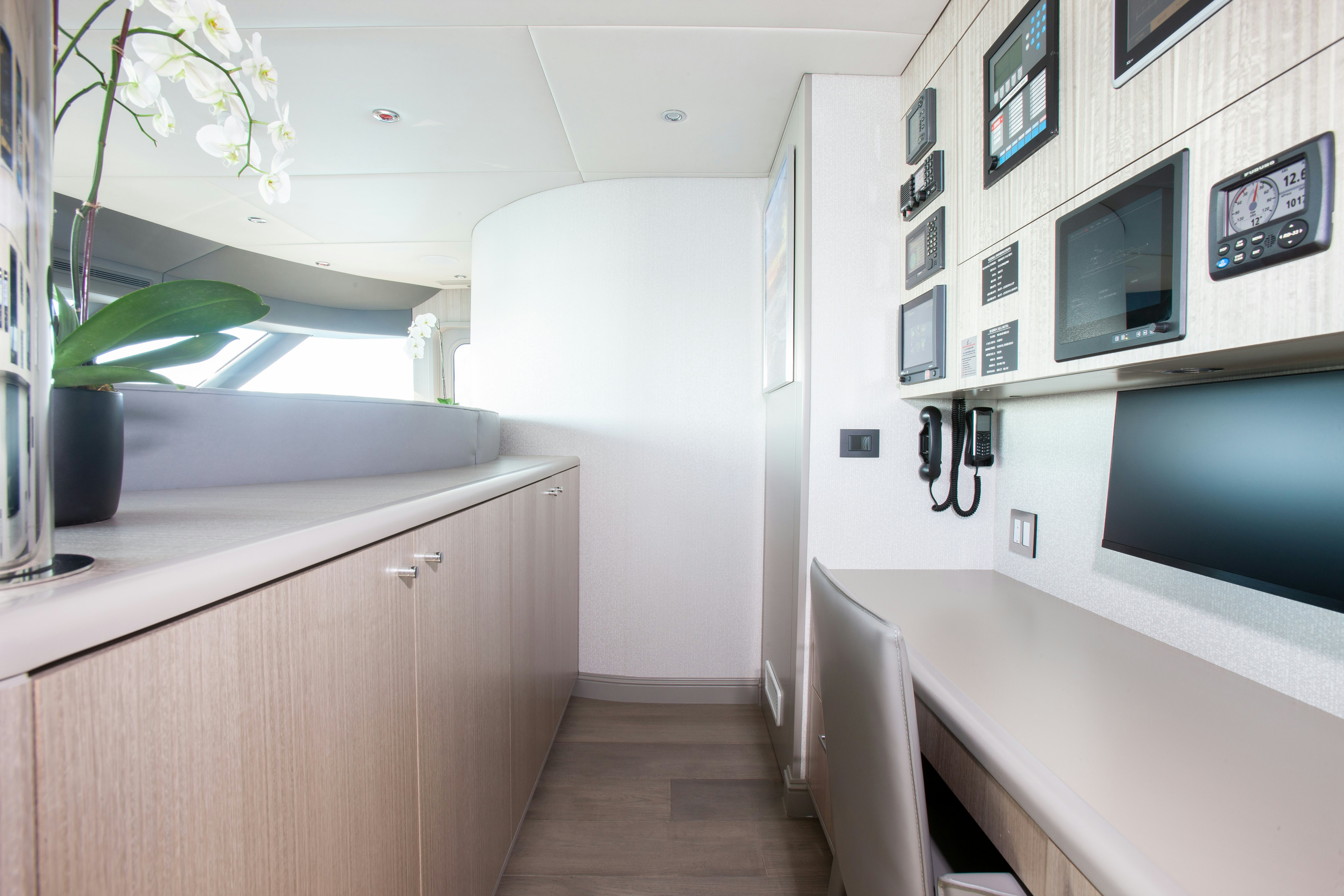 a room with a desk and a television aboard NO BAD IDEAS Yacht for Sale