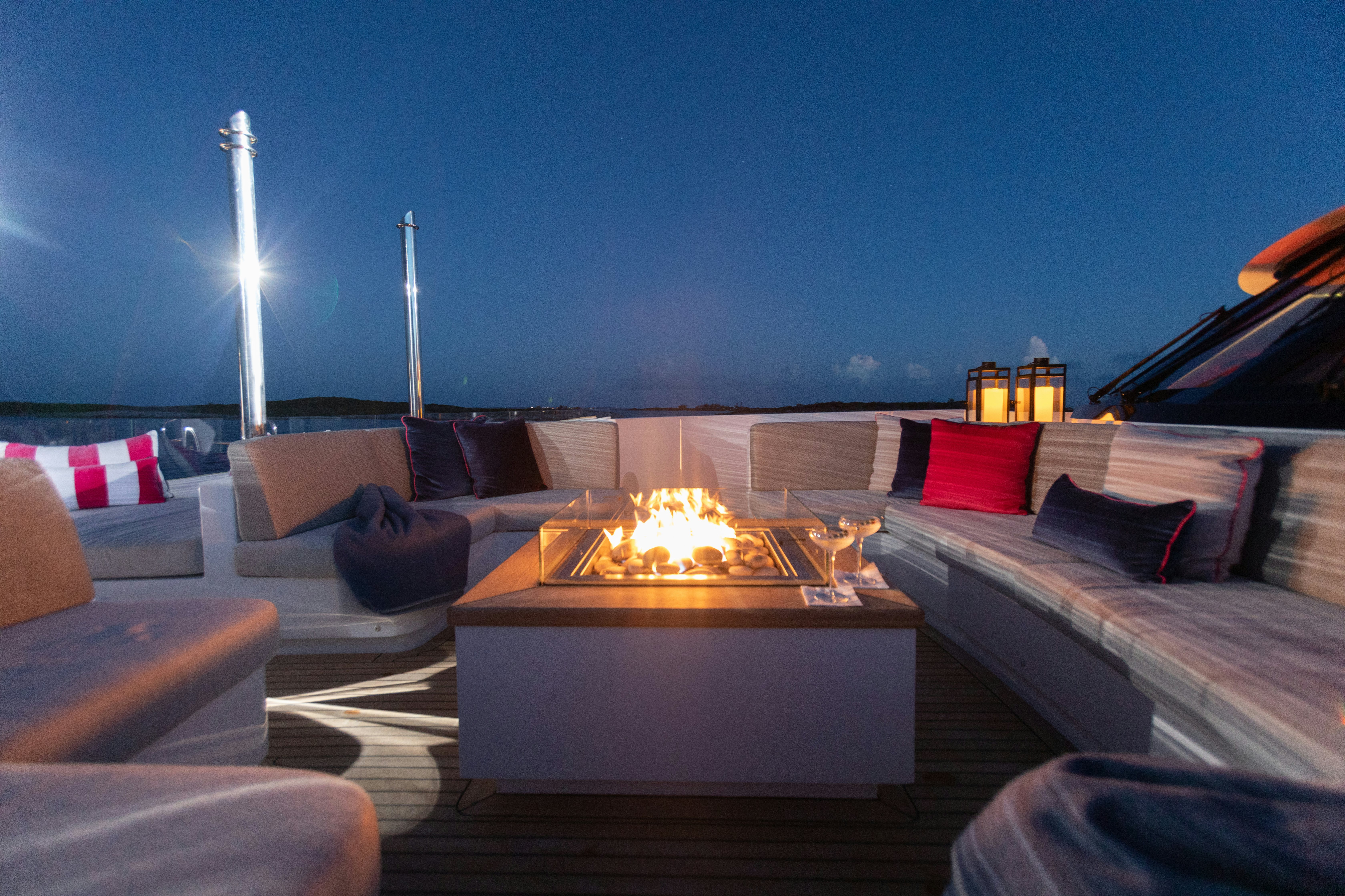 a room with a fire pit and couches aboard NO BAD IDEAS Yacht for Sale