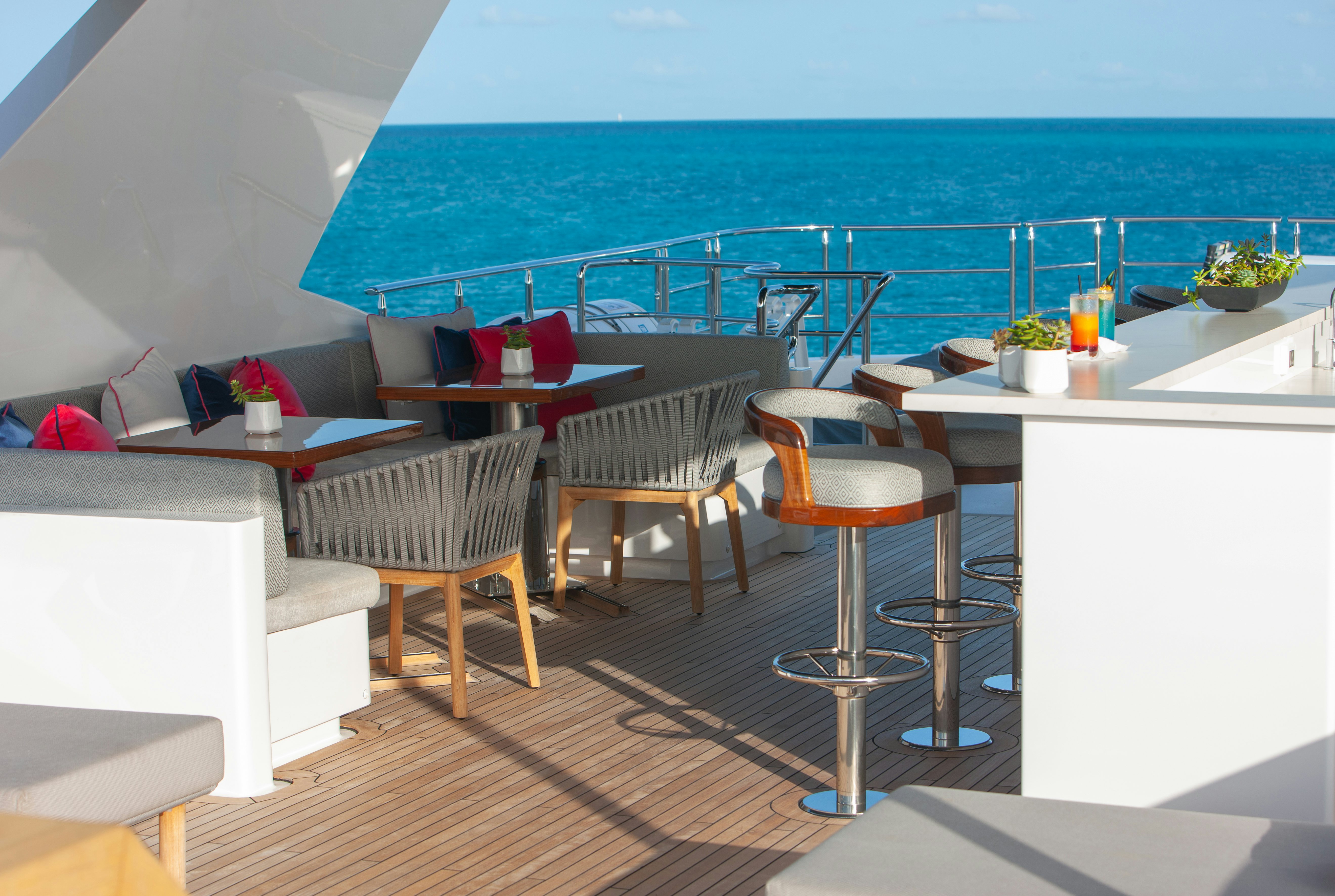a room with tables and chairs aboard NO BAD IDEAS Yacht for Sale