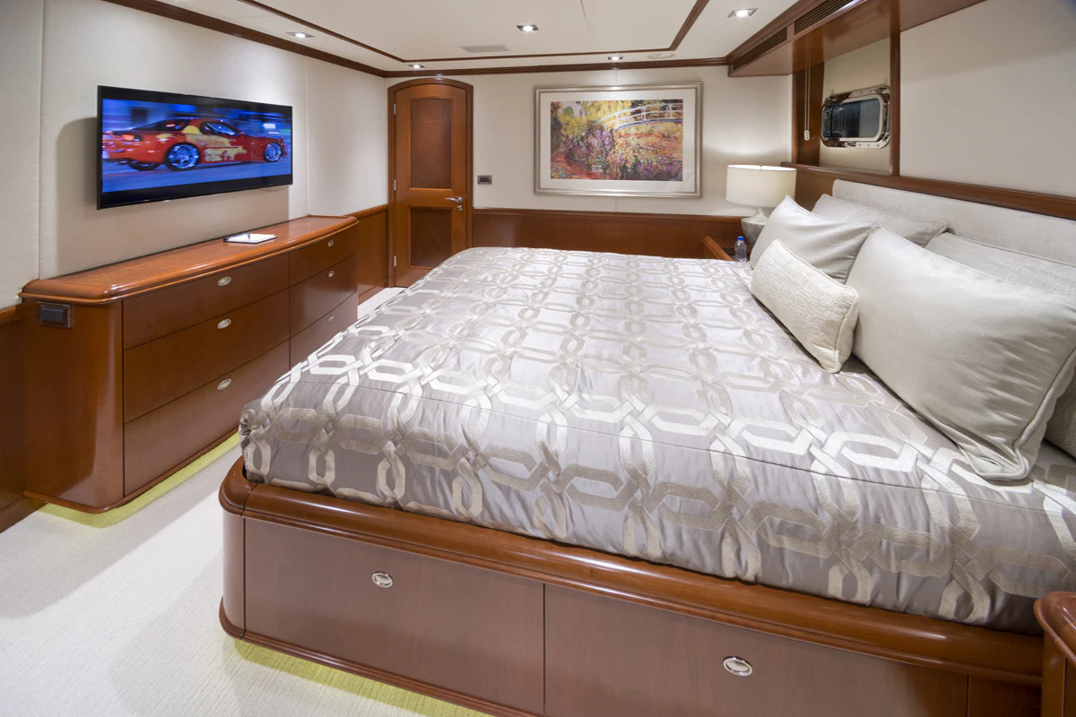 a bed with a television on the wall aboard FORE ACES Yacht for Sale