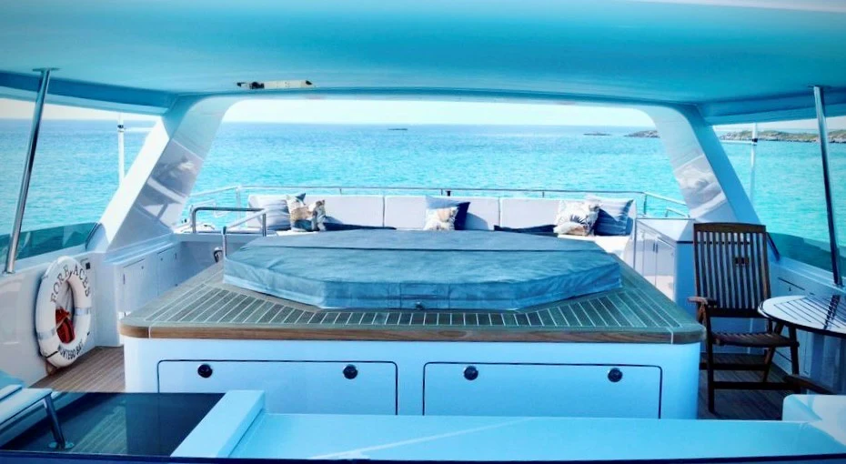 a large white boat with a large deck and a deck with a view of the water aboard FORE ACES Yacht for Sale