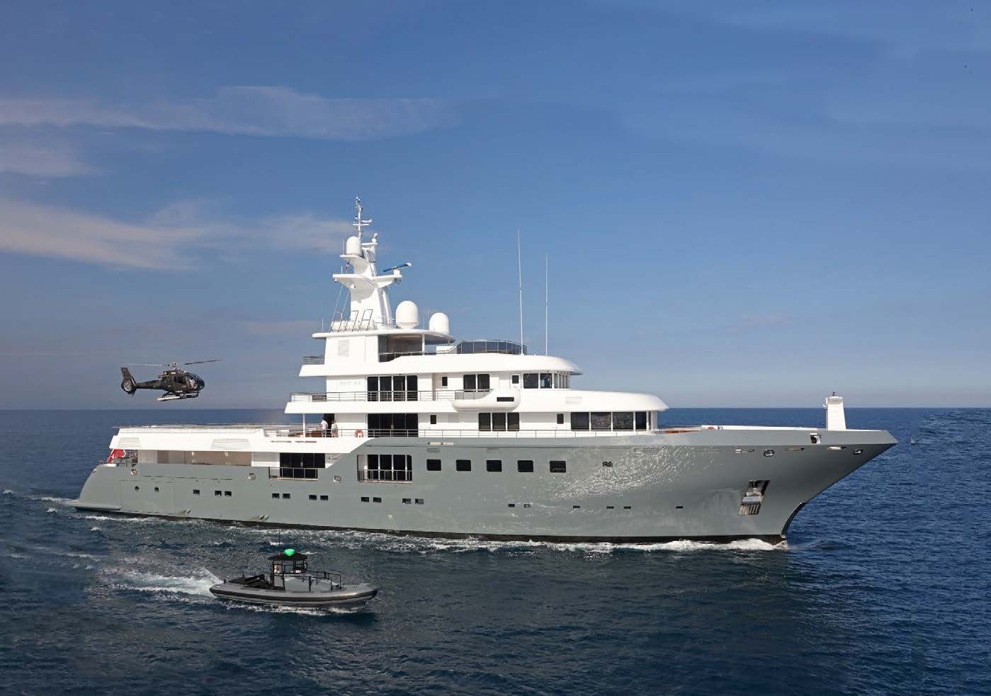 a helicopter flying over a large white boat aboard PLANET NINE Yacht for Sale