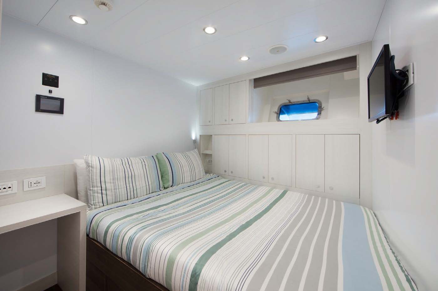 a bedroom with a bed and a television aboard PLANET NINE Yacht for Sale