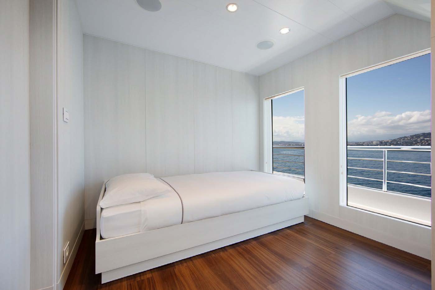 a bedroom with a large window aboard PLANET NINE Yacht for Sale