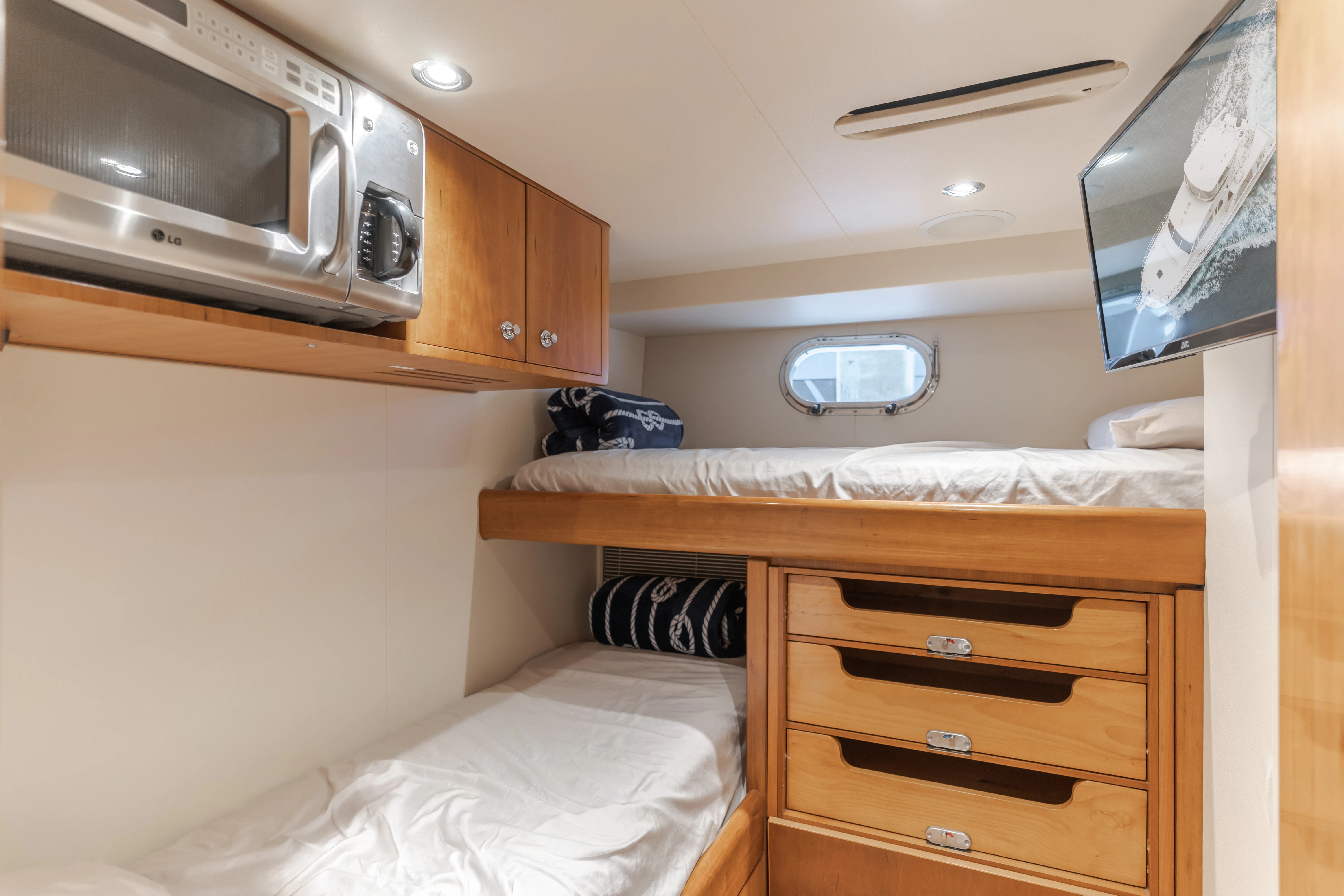 a bedroom with a microwave oven and a bed aboard EASY Yacht for Sale