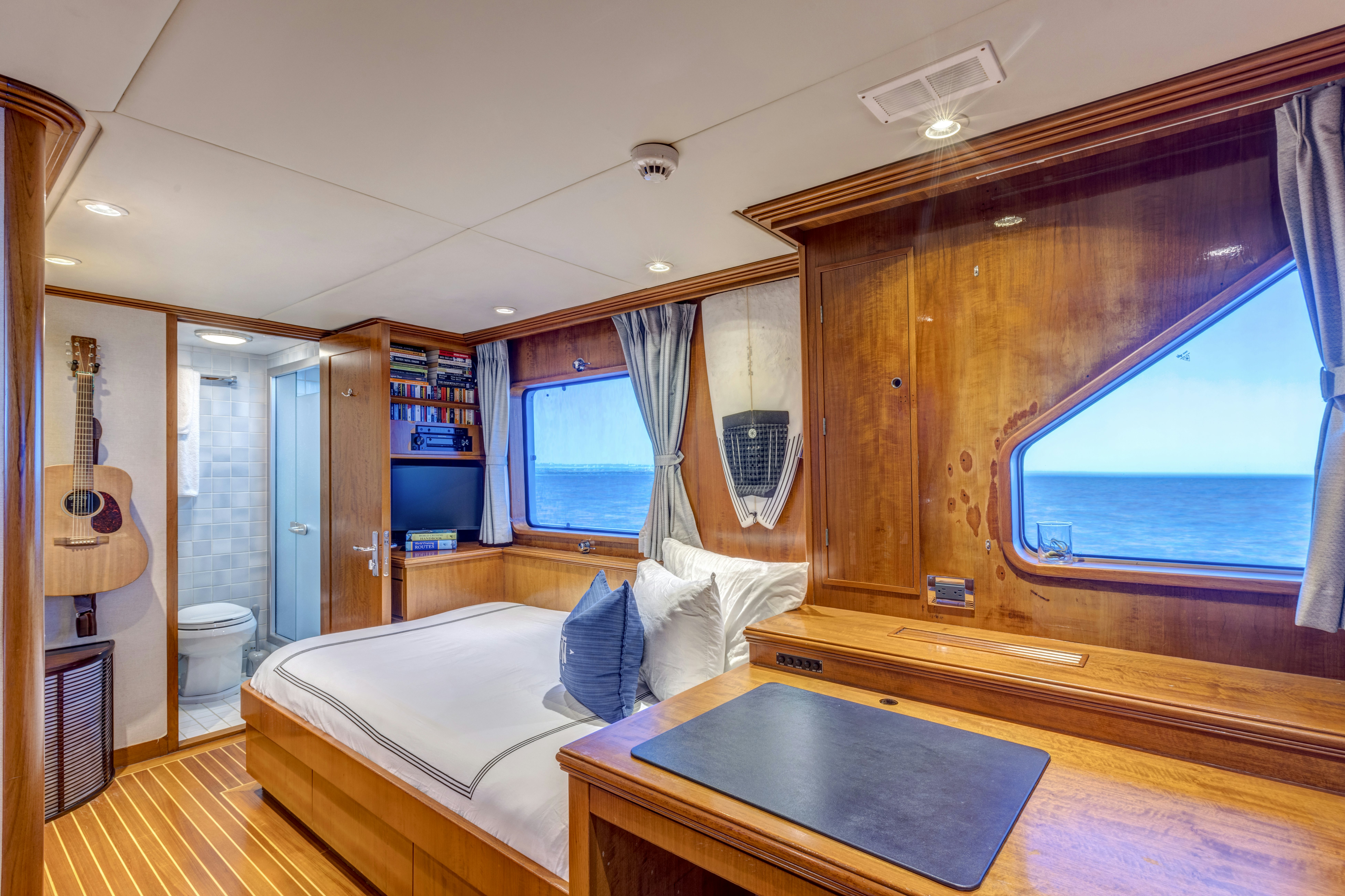 a bedroom with a bed and a table aboard TRUE NORTH Yacht for Sale