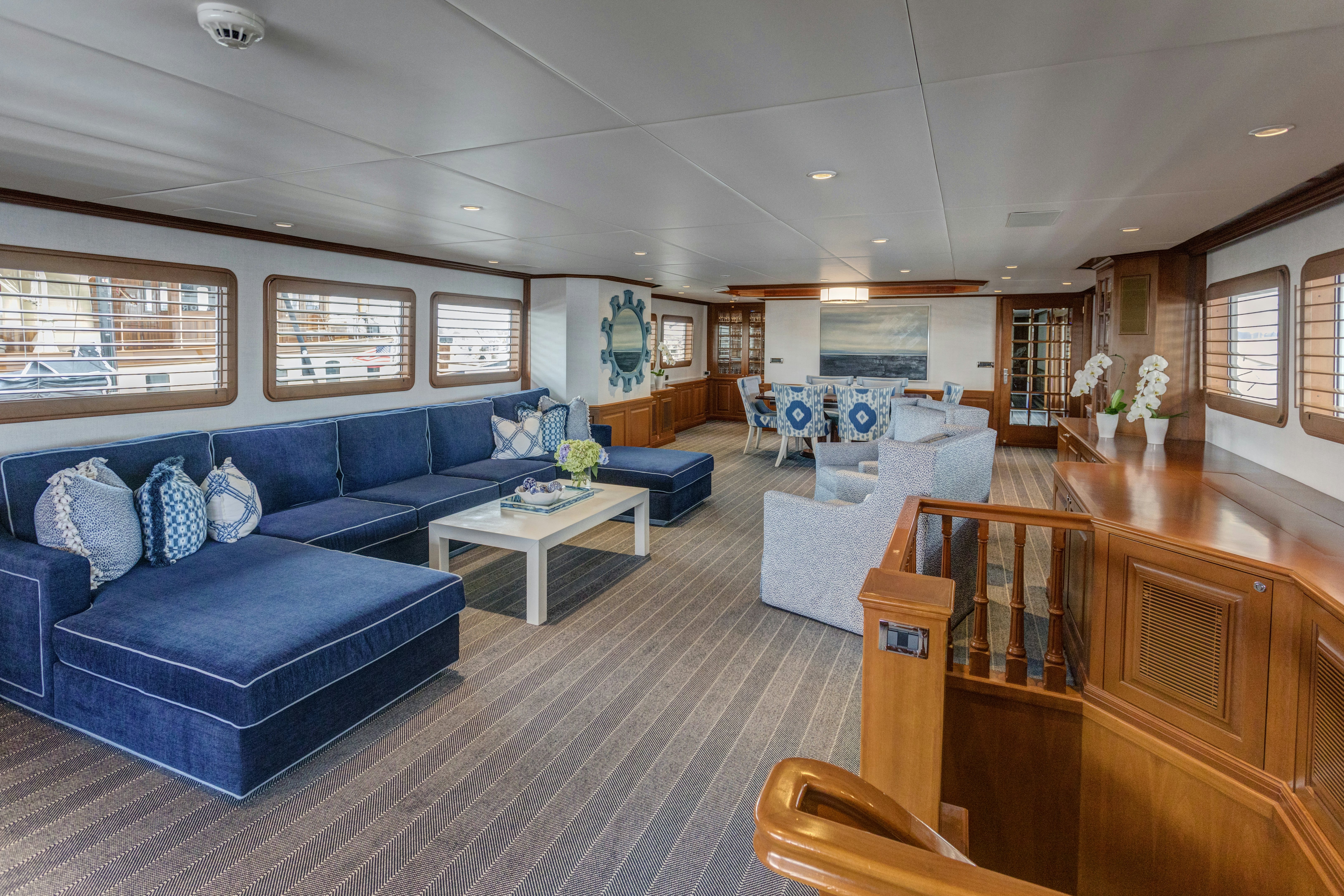 a living room with blue couches aboard TRUE NORTH Yacht for Sale