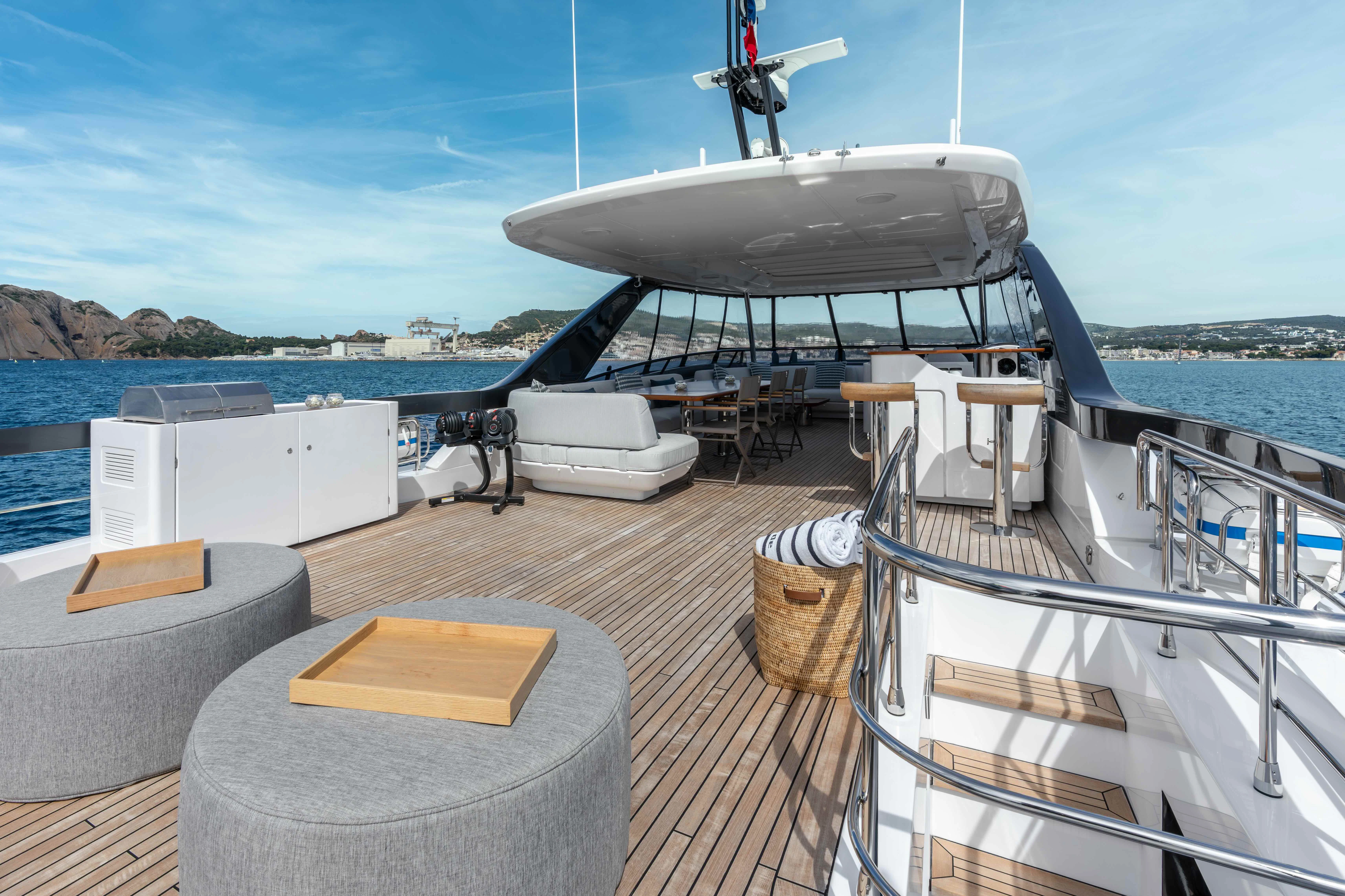 a deck with a boat and a table on it aboard ST JUDE Yacht for Sale