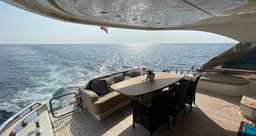 a table and chairs on a deck overlooking the ocean aboard CRAZY DIAMOND Yacht for Sale