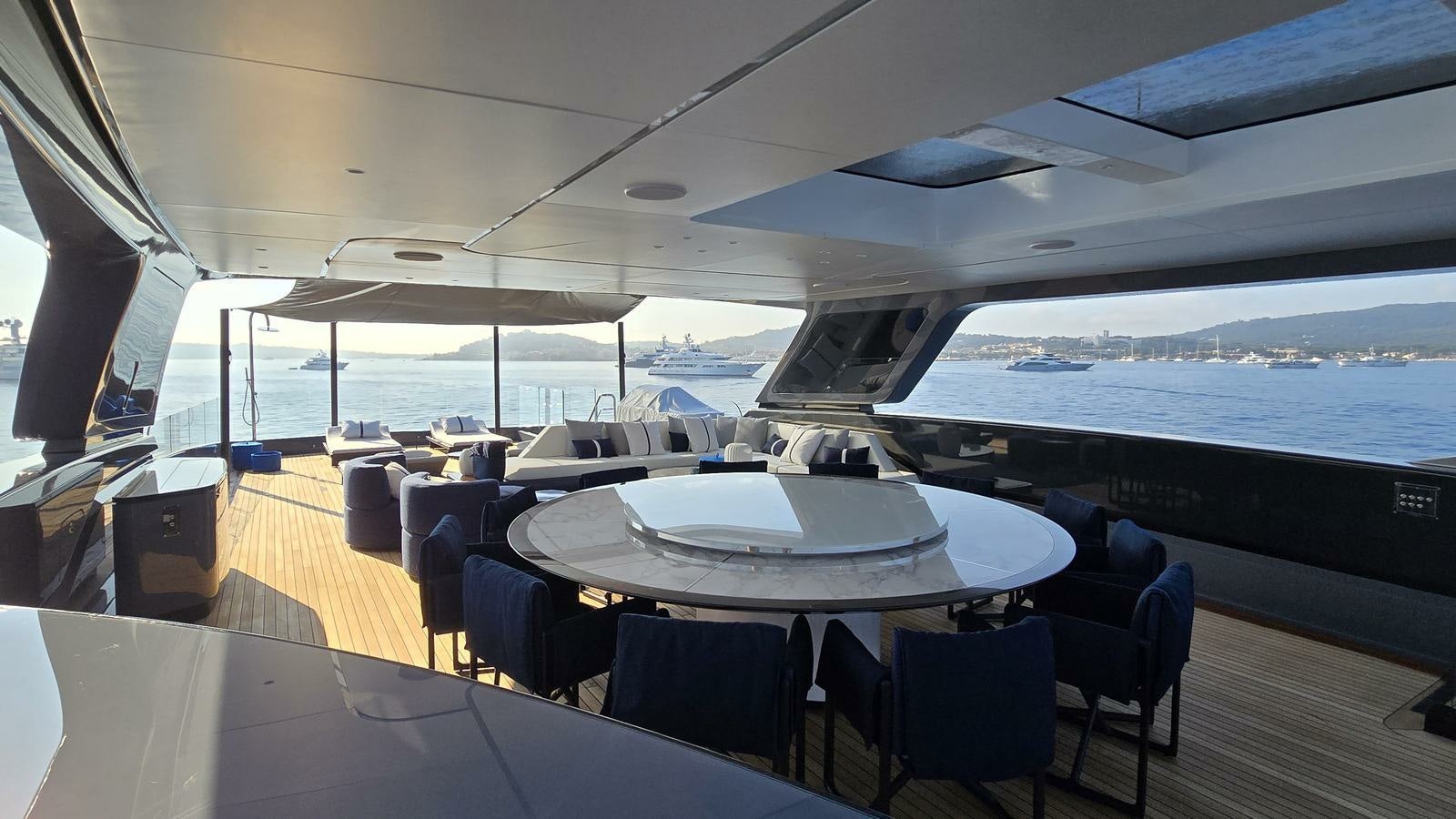 a room with tables and chairs aboard AKULA Yacht for Charter