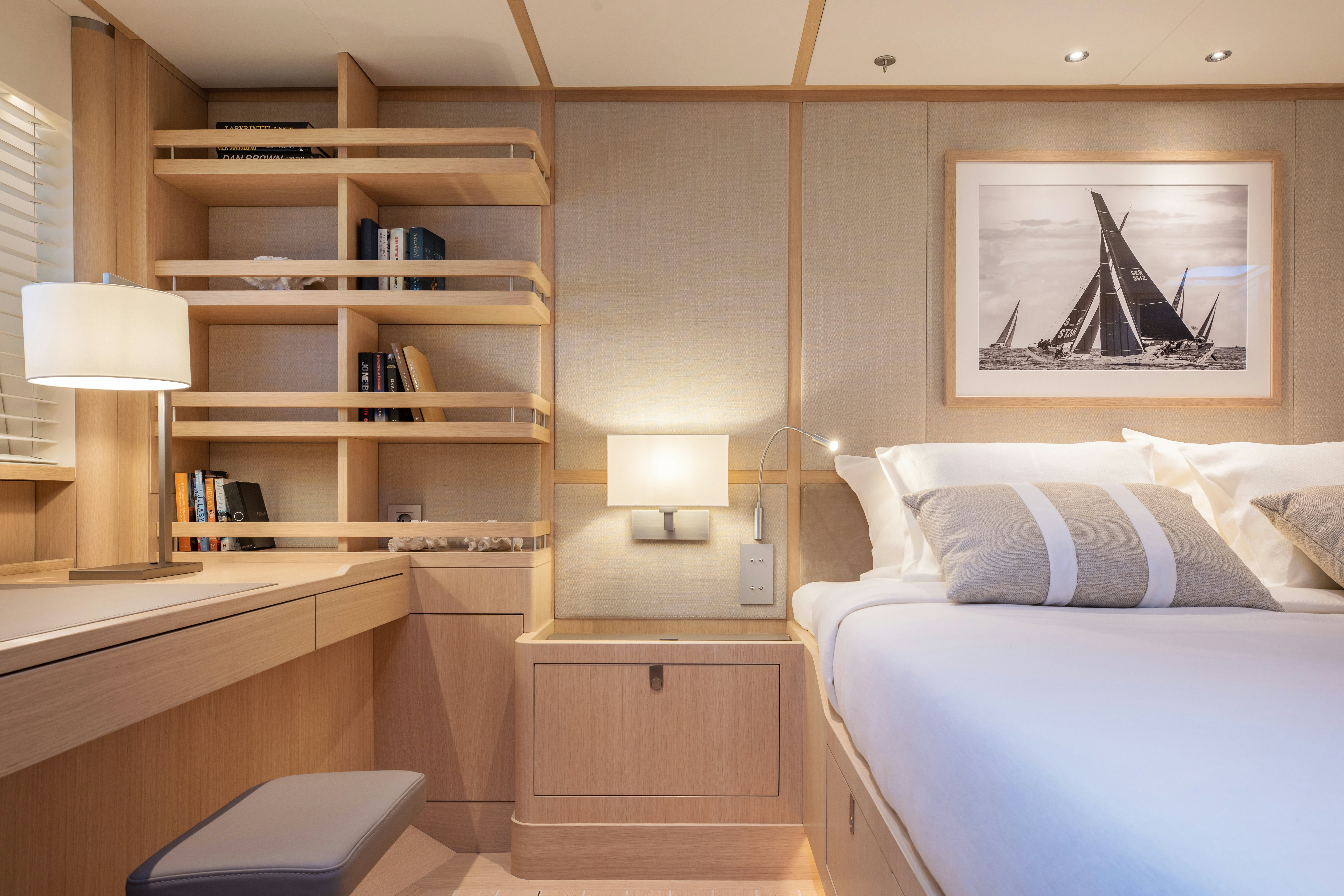 a room with a bed and a shelf with books on it aboard ALIX Yacht for Sale