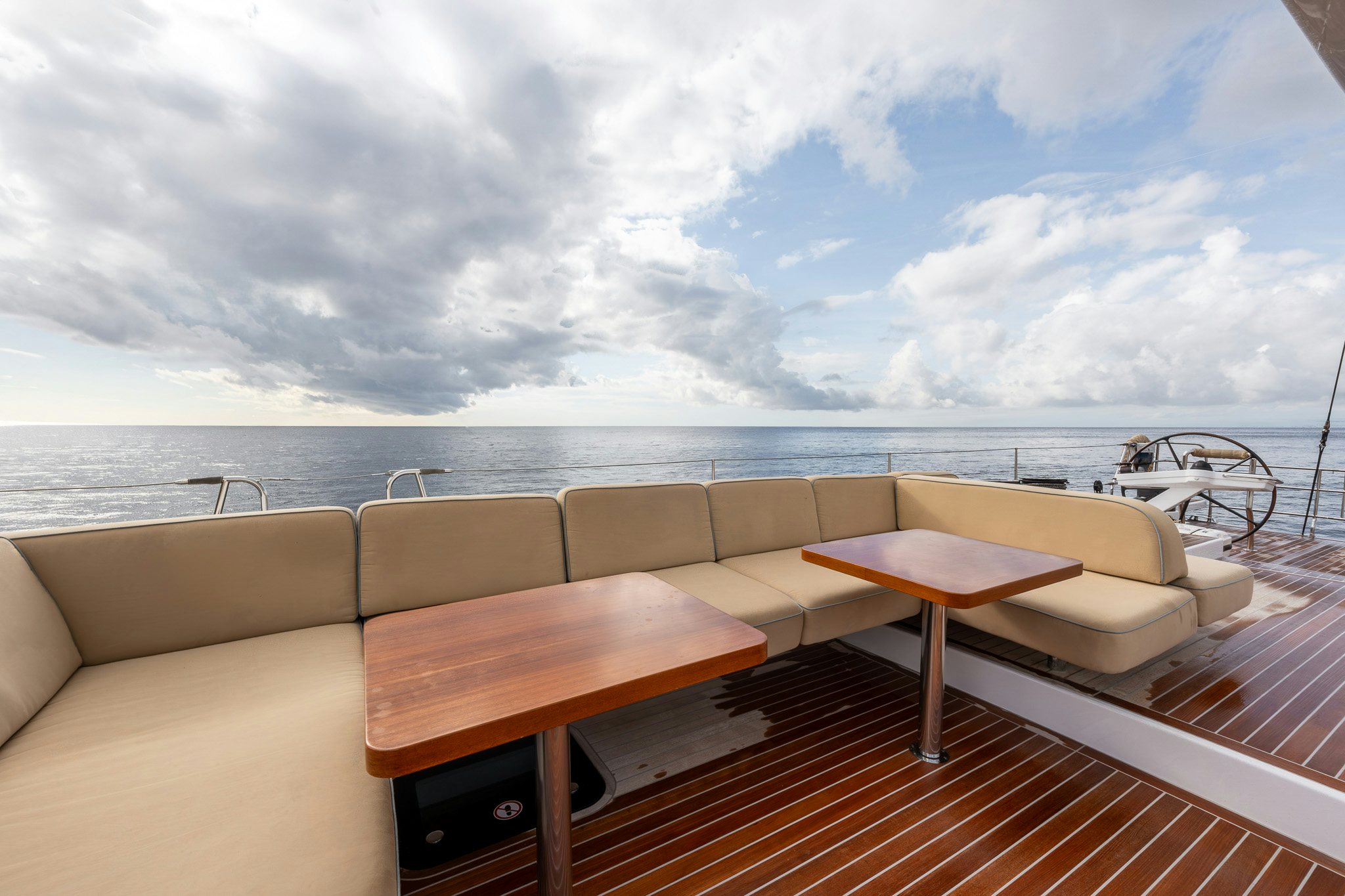 a table and bench on a deck overlooking a body of water aboard ALIX Yacht for Sale