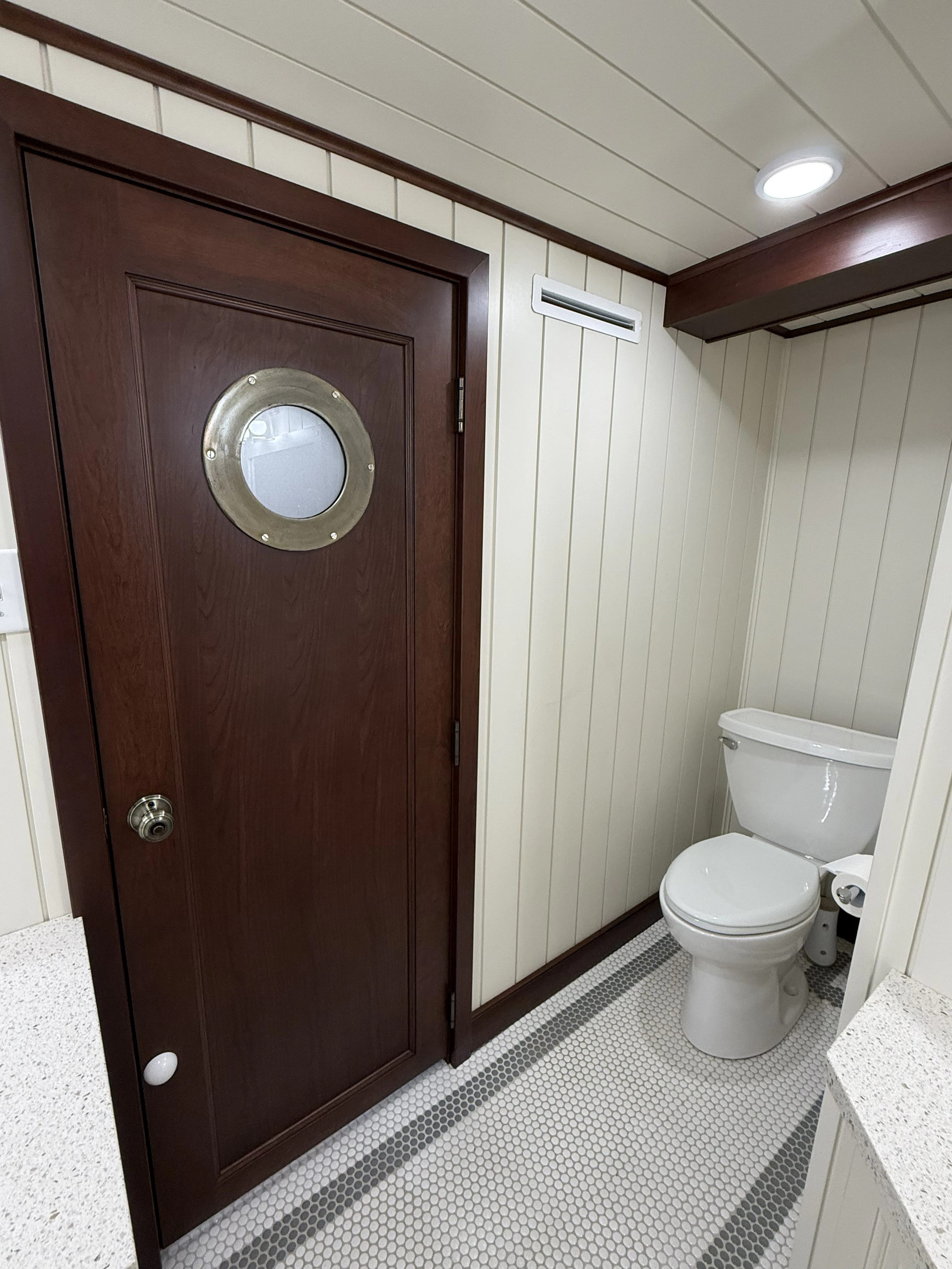 a bathroom with a toilet and a wooden door aboard ANNE S PIERCE Yacht for Sale