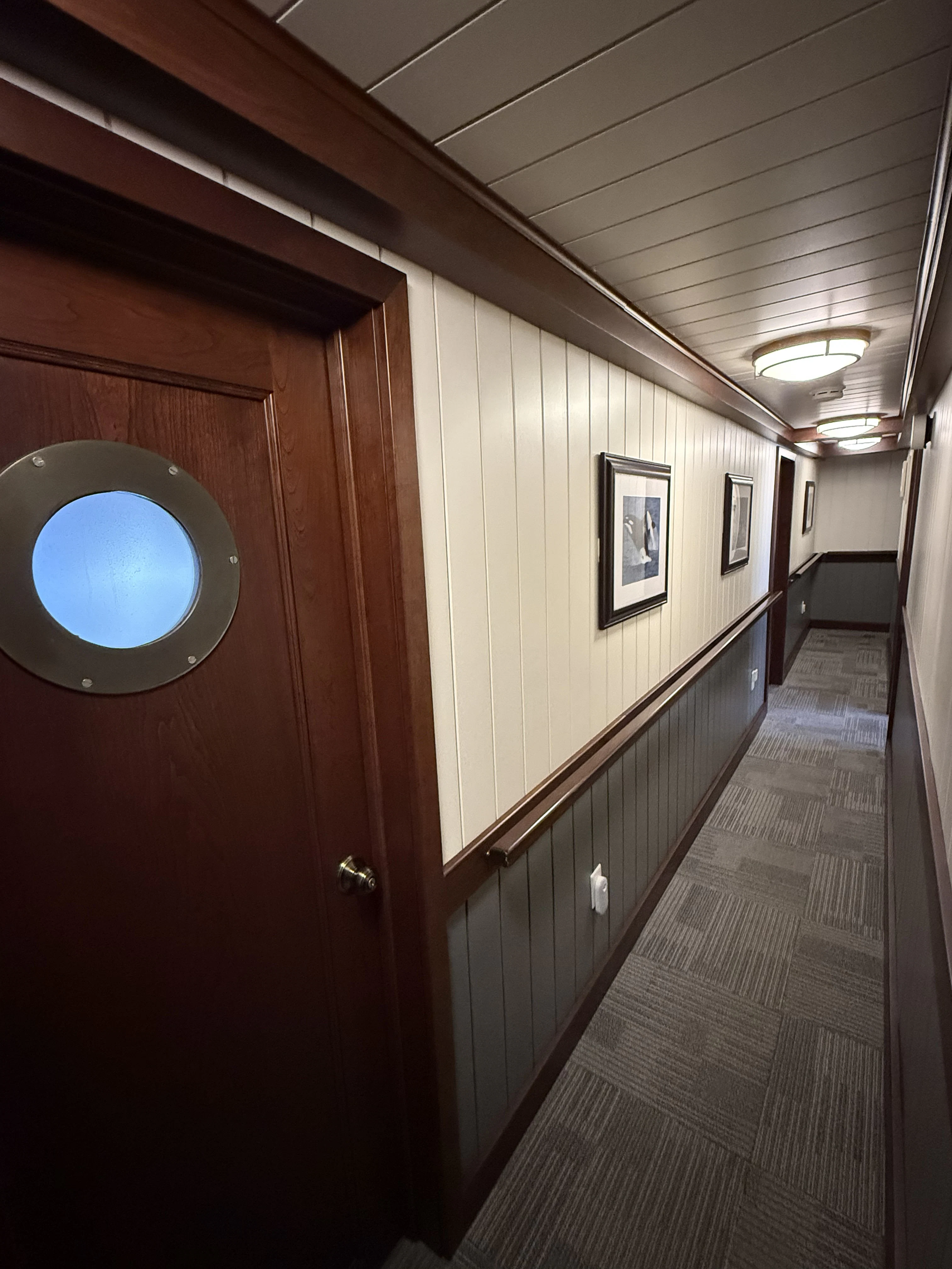 a hallway with a wood door and a blue circle on the wall aboard ANNE S PIERCE Yacht for Sale
