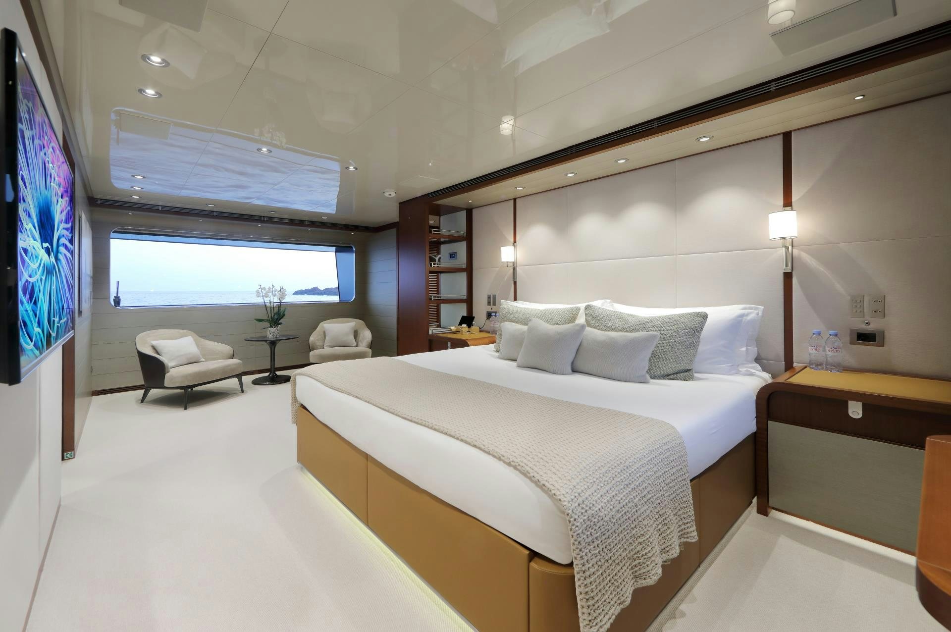 a room with a bed and a tv on the wall aboard X Yacht for Sale