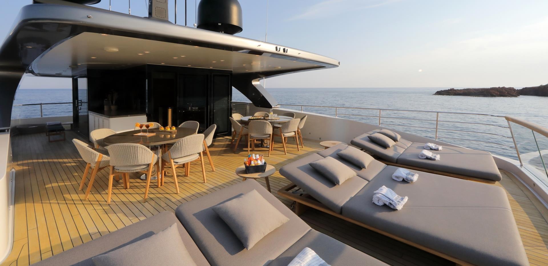 a deck with a couch and chairs on it aboard X Yacht for Sale