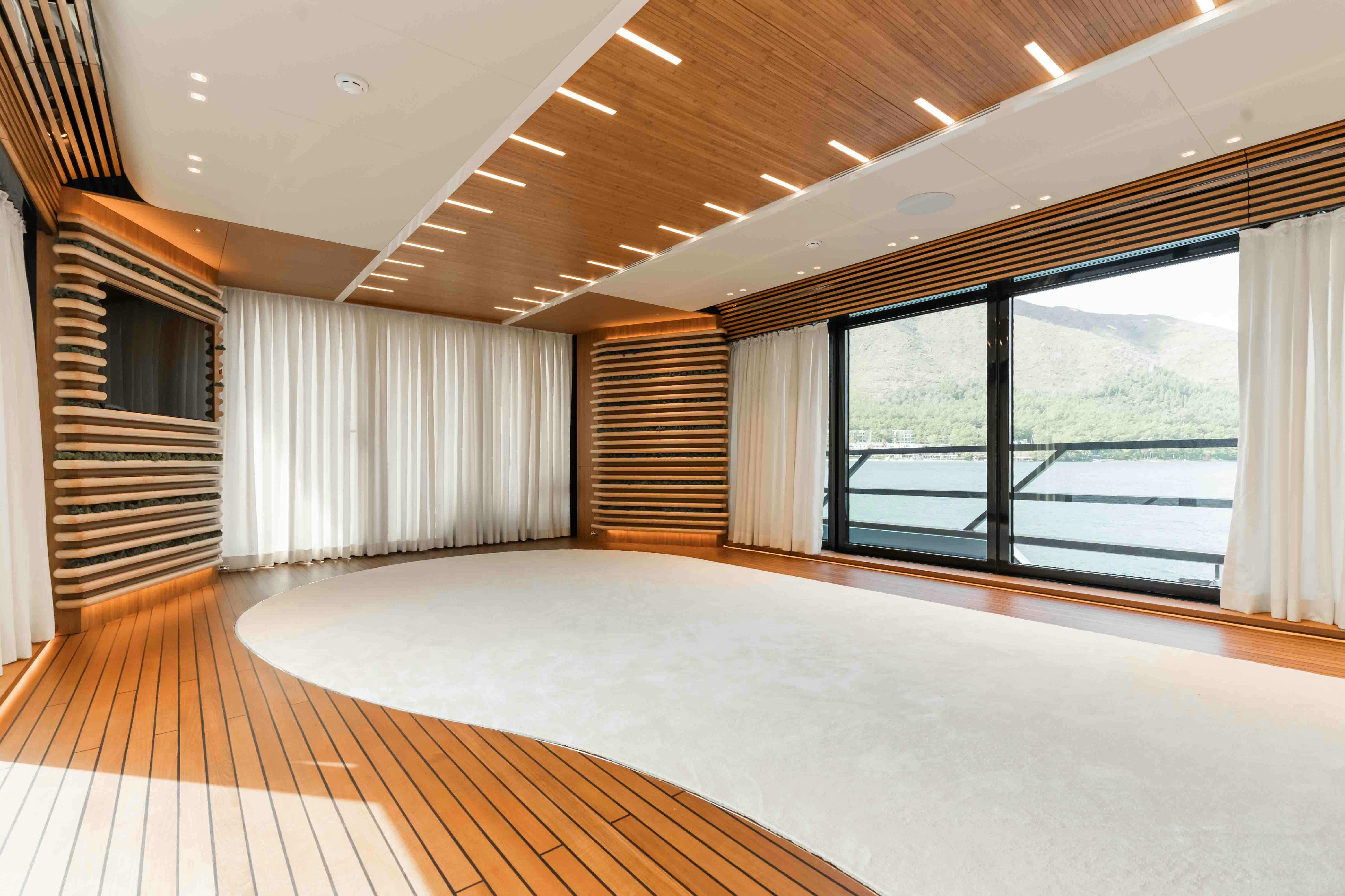 a large room with a large window and a wood staircase aboard NB 202 Yacht for Sale