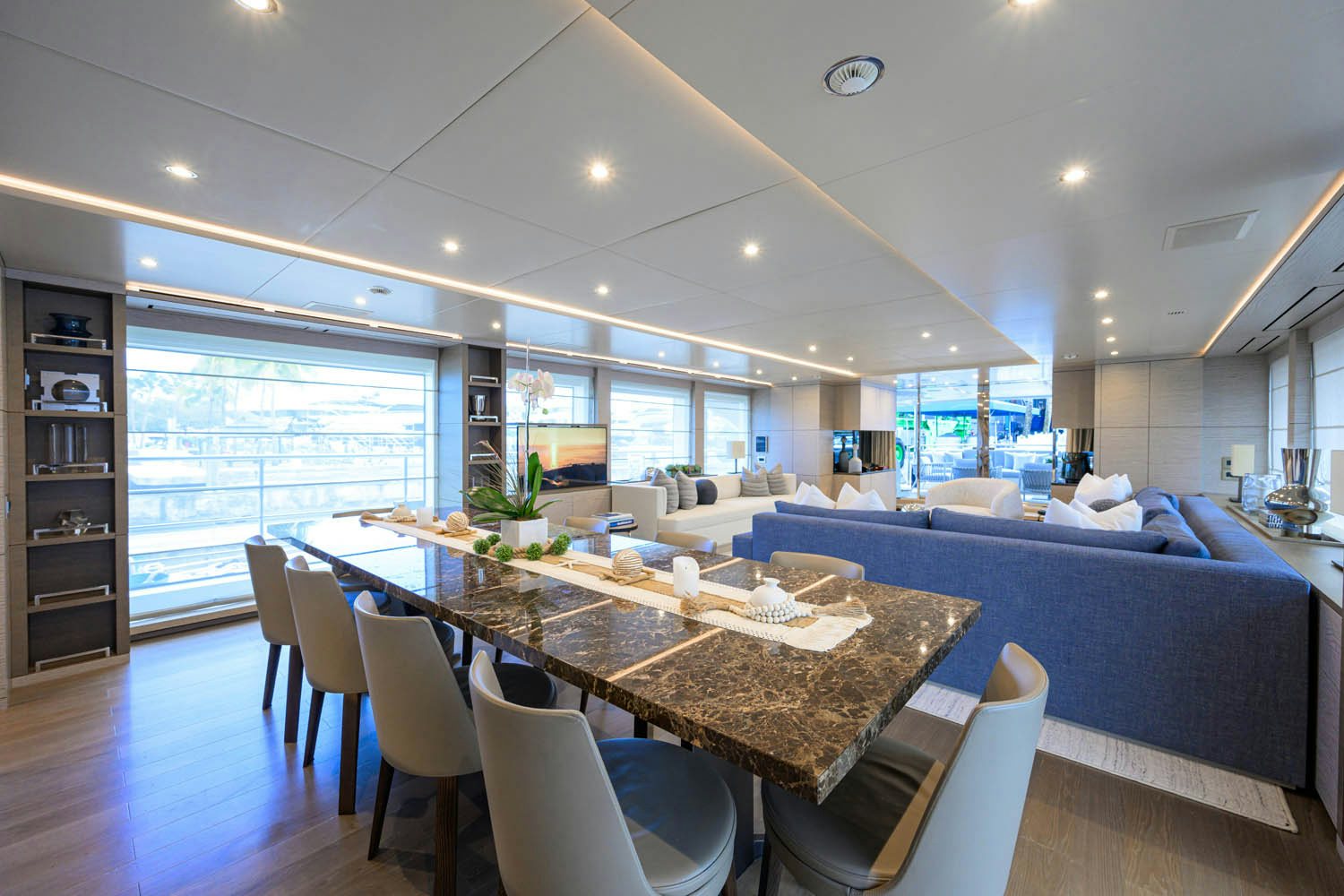 a large room with a table and chairs aboard COFINA Yacht for Charter