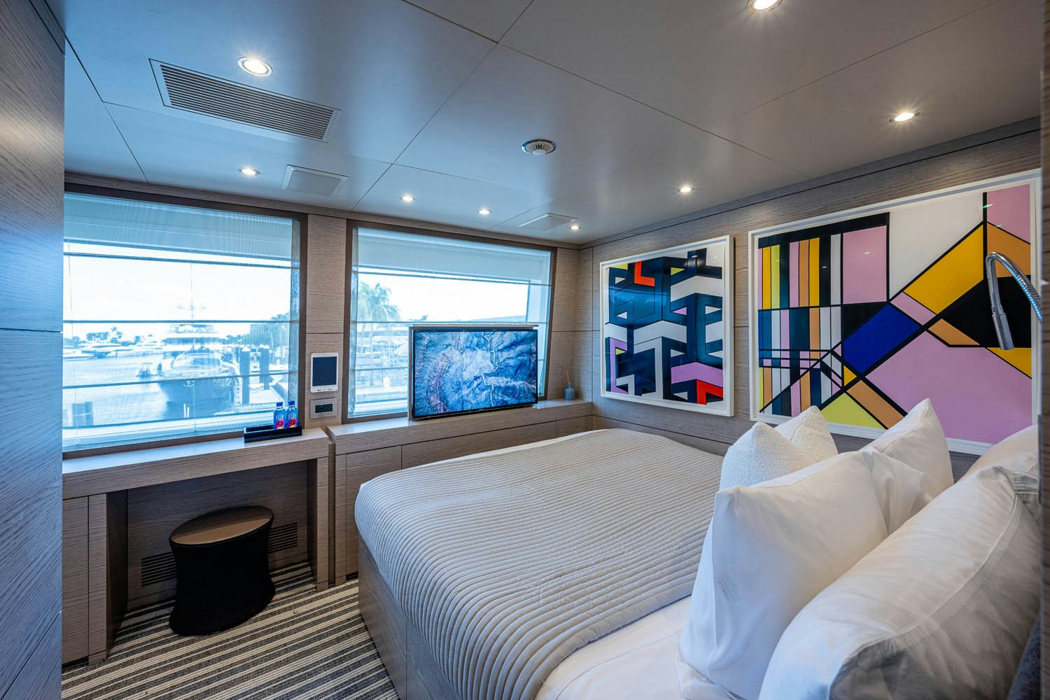 a bedroom with a bed and a window aboard COFINA Yacht for Charter