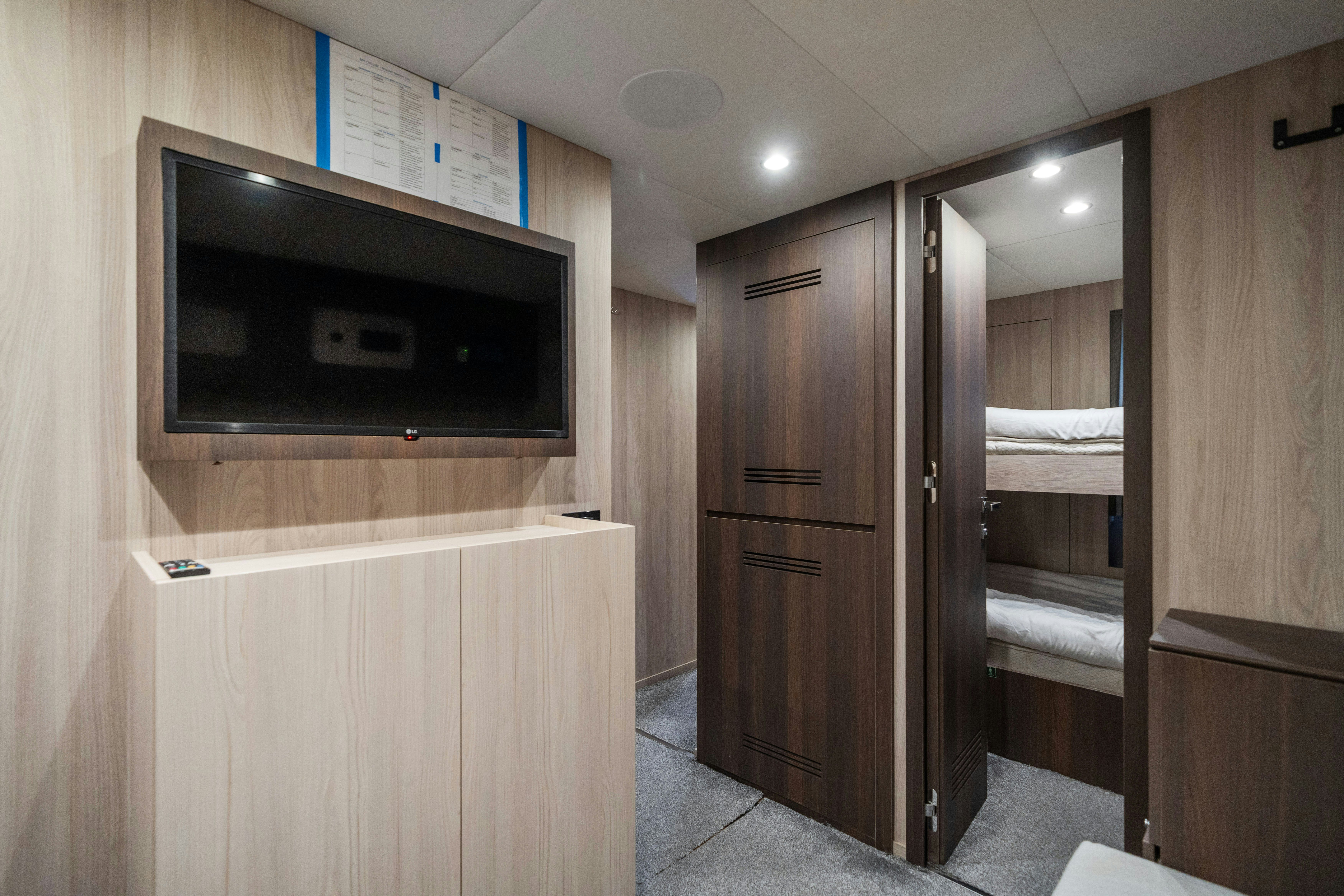 a room with a tv and a closet aboard CHILLIN’ Yacht for Sale