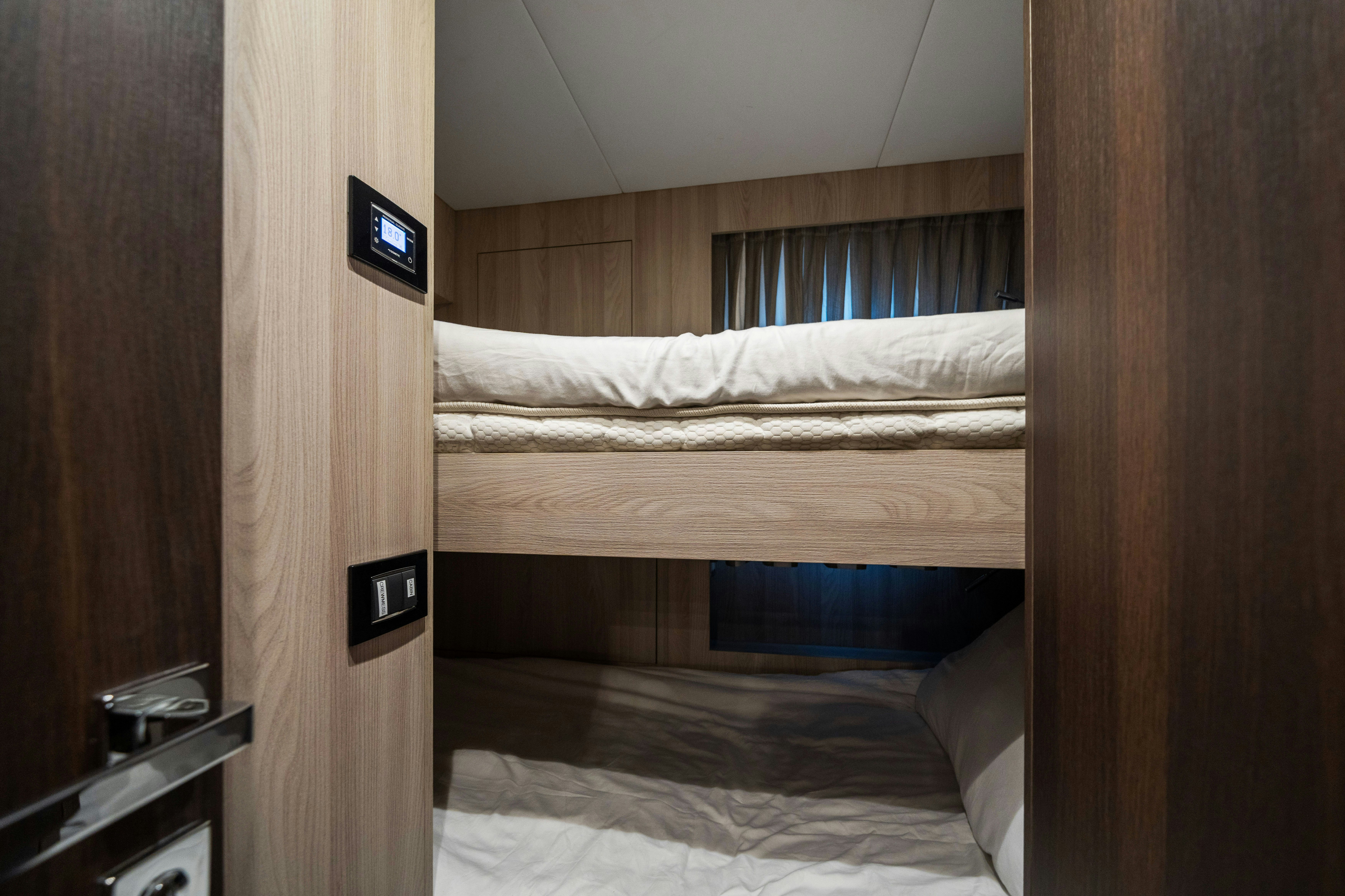 a room with a bed and a telephone aboard CHILLIN’ Yacht for Sale