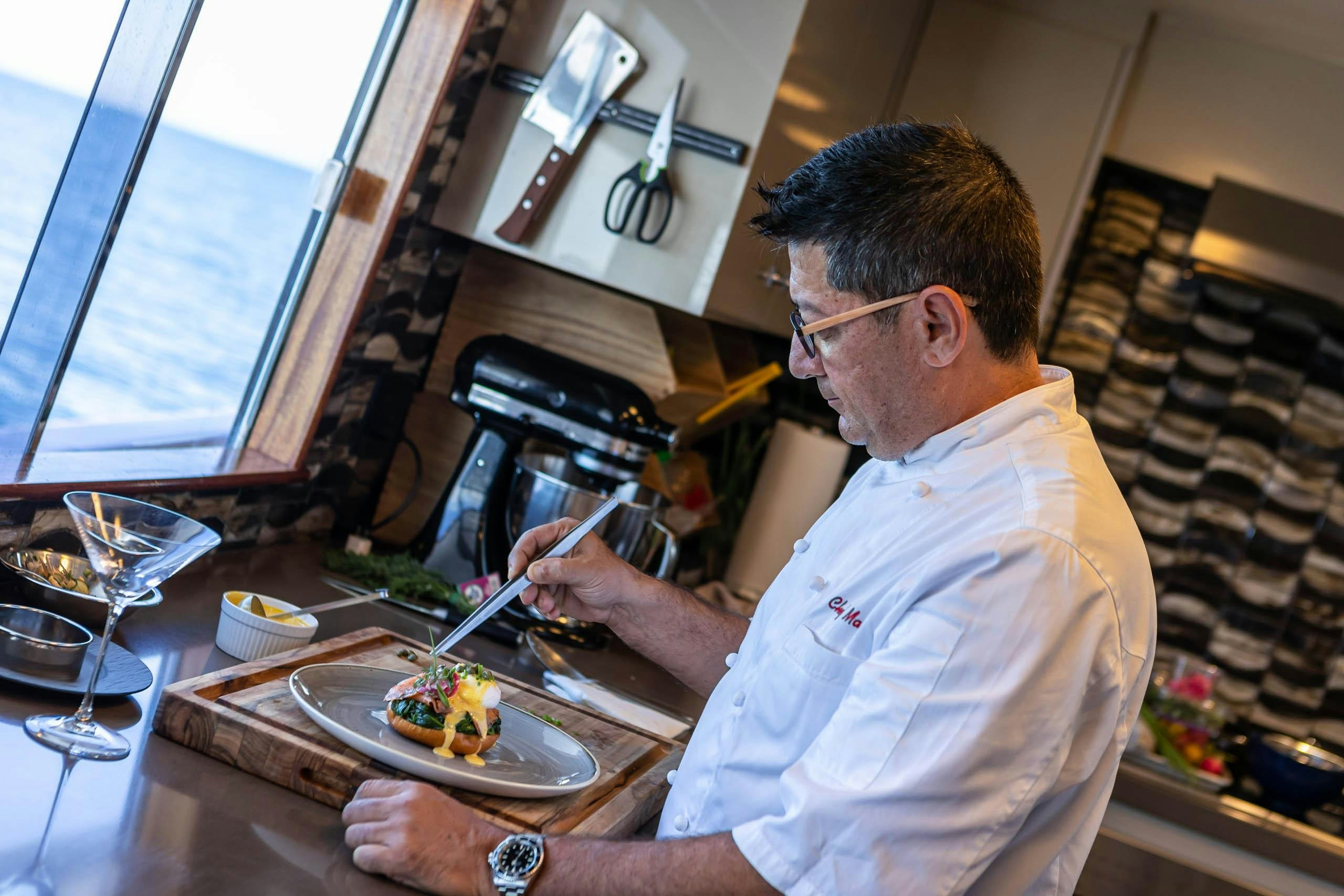 a man is preparing food in the kitchen aboard EL REY Yacht for Charter