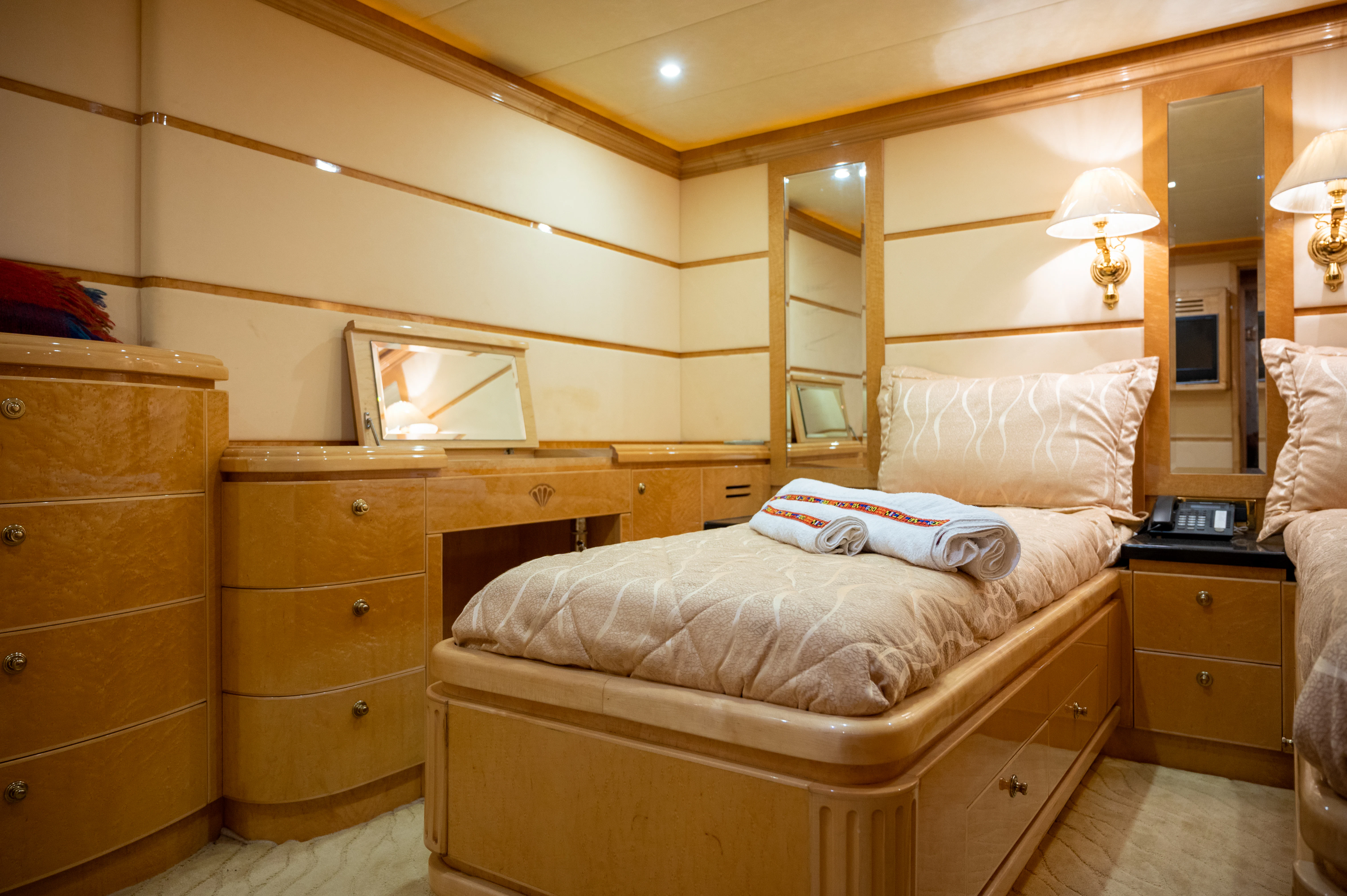 a bedroom with a bed and a dresser aboard LADY EILEEN II Yacht for Sale
