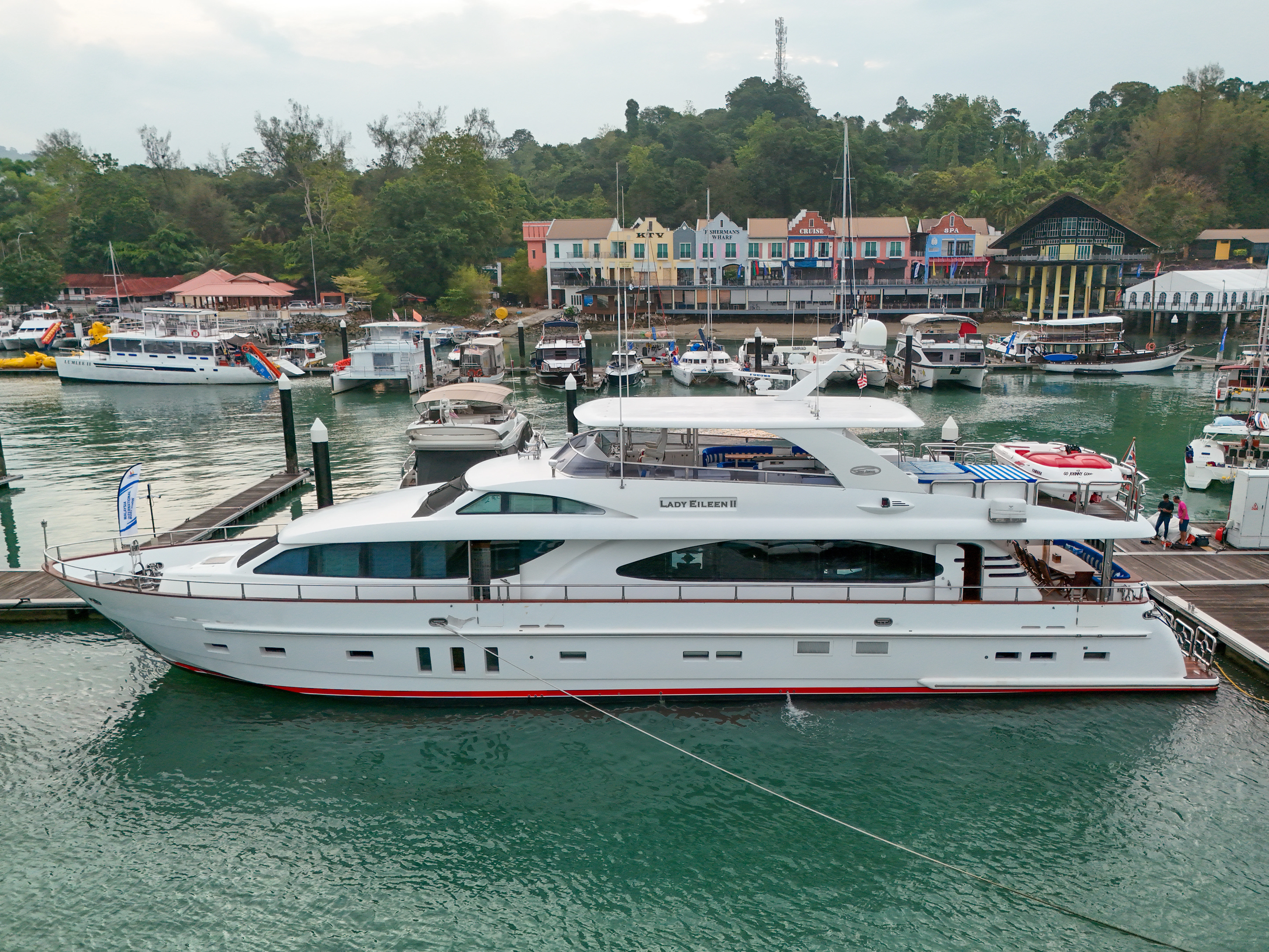a large white boat sits in a harbor aboard LADY EILEEN II Yacht for Sale