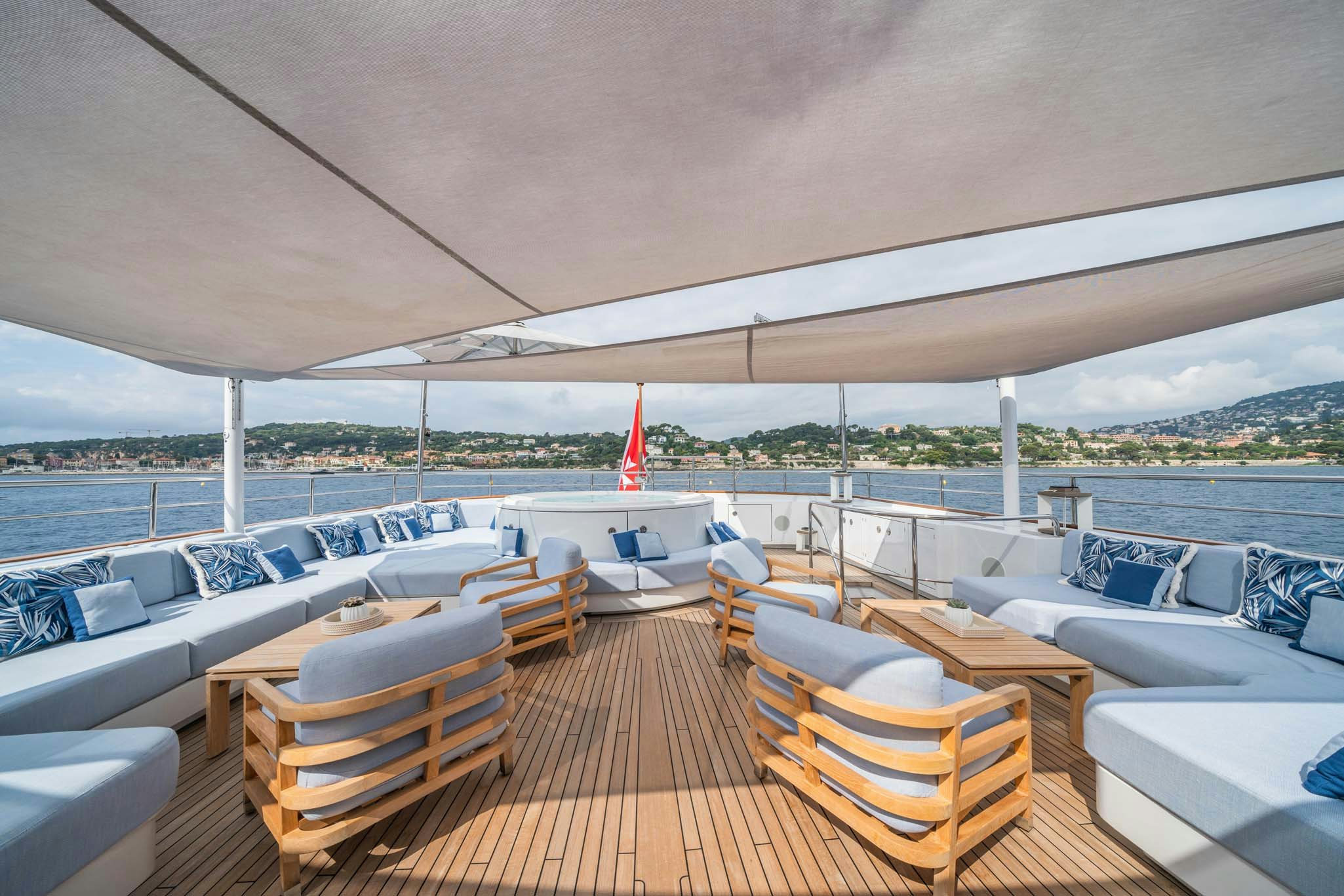 a deck with chairs and a large body of water in the background aboard SYNTHESIS 66 Yacht for Charter