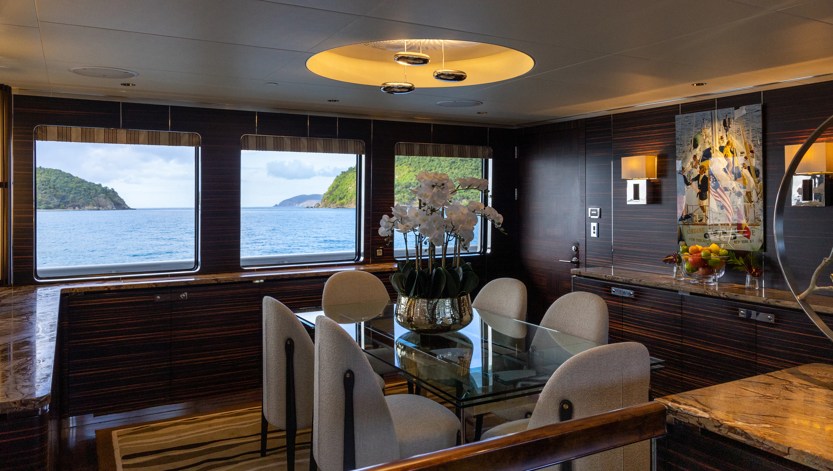 inside of a building with a table and chairs and a window with a painting on the wall aboard AVALON Yacht for Charter