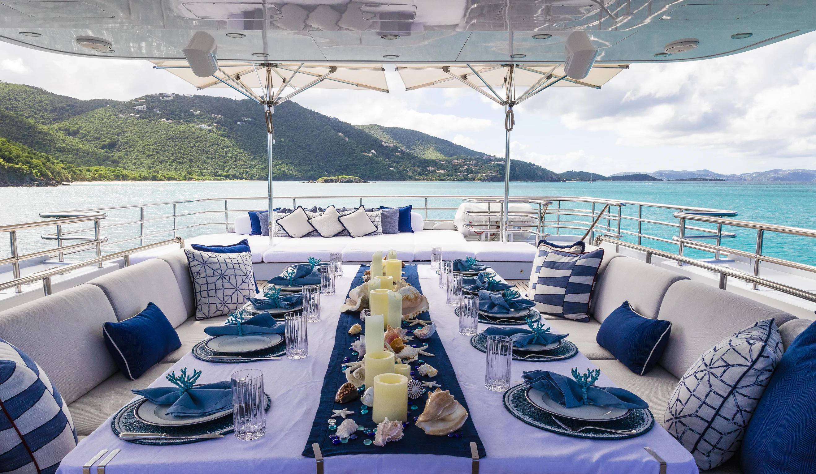 a large blue and white lounge area with a large white table and chairs and a large body of aboard AVALON Yacht for Charter