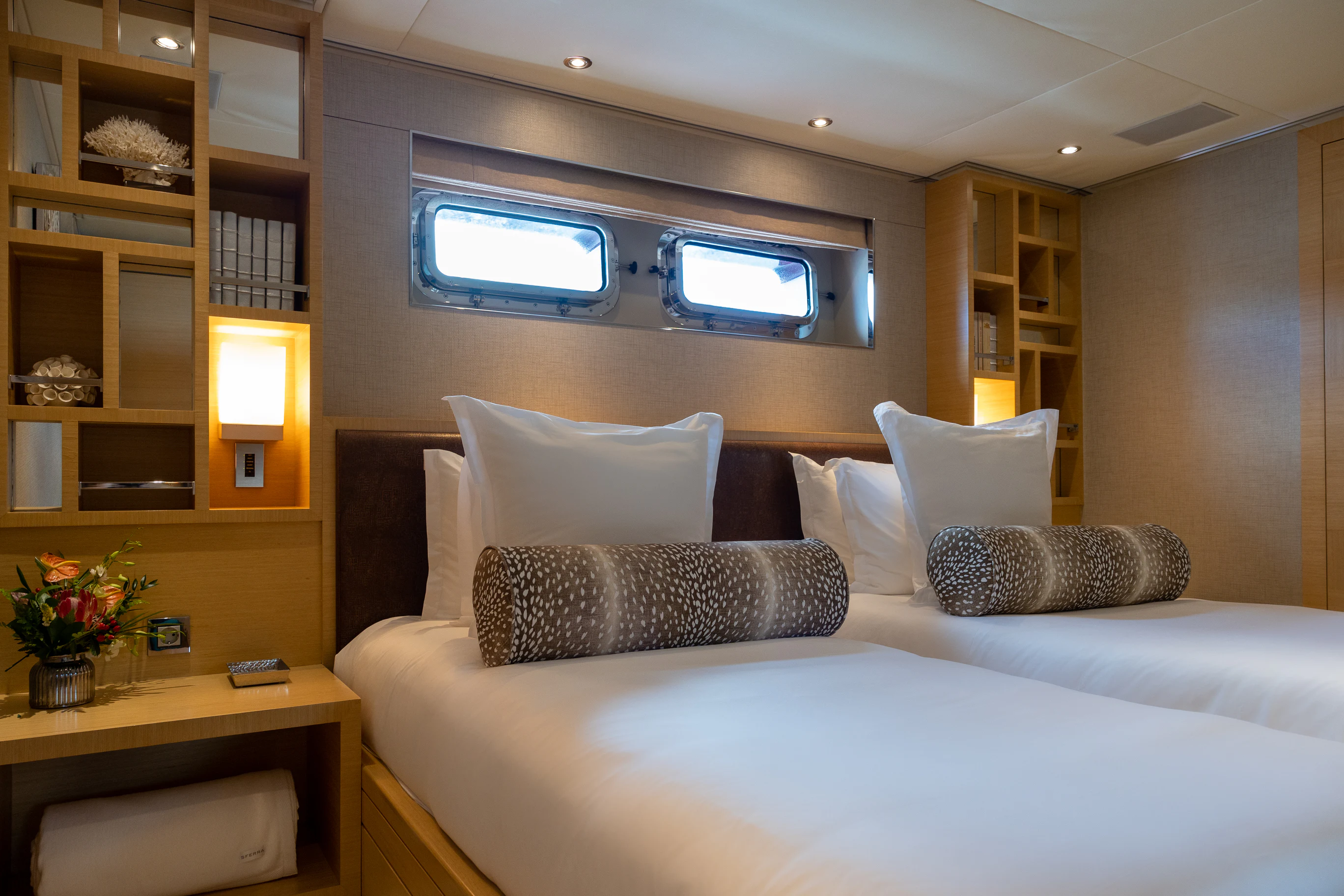 a bed with pillows and a tv on the wall aboard AVALON Yacht for Charter