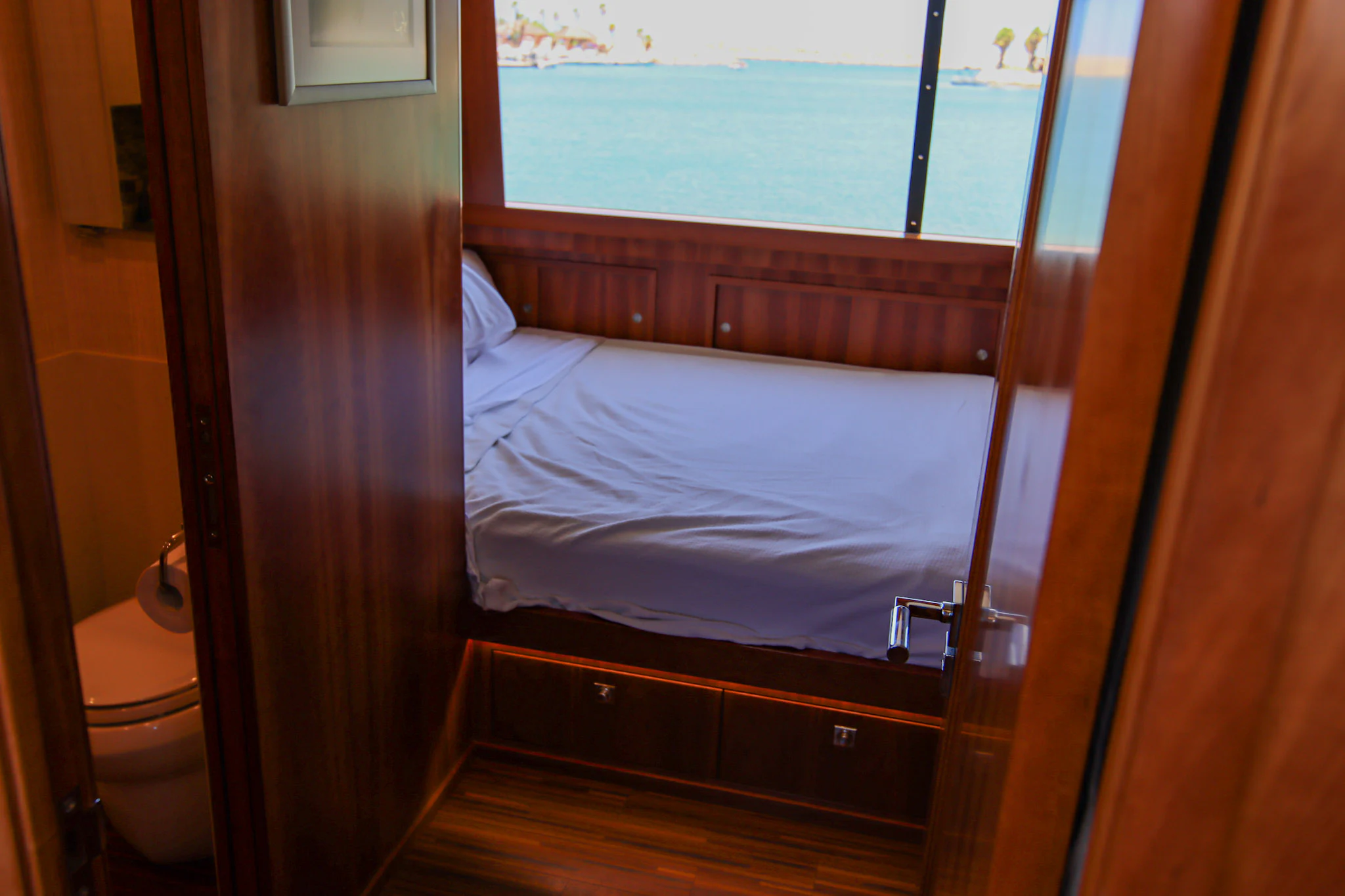 a bed next to a window aboard MARDIOSA Yacht for Sale