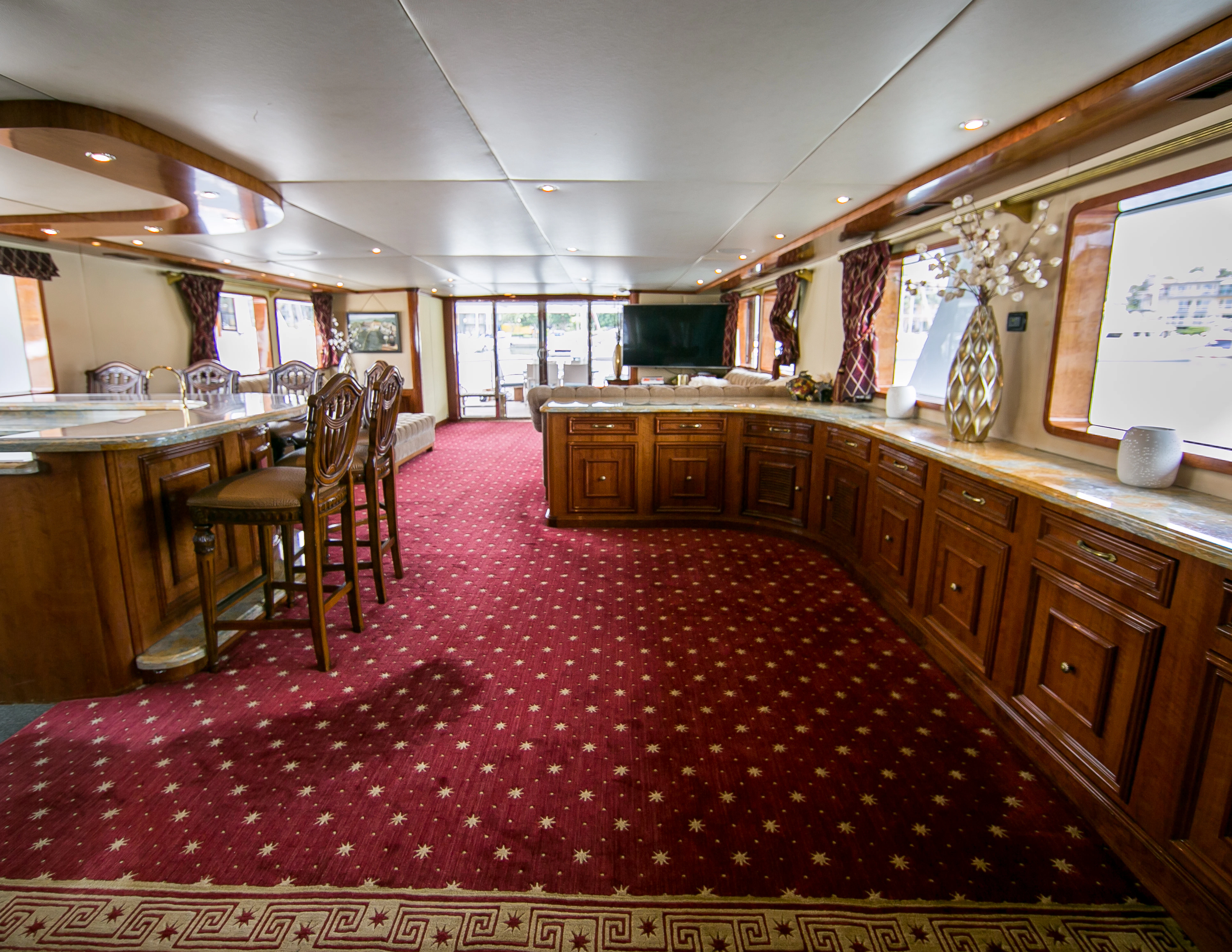 a large room with a red carpet aboard AURORA Yacht for Sale