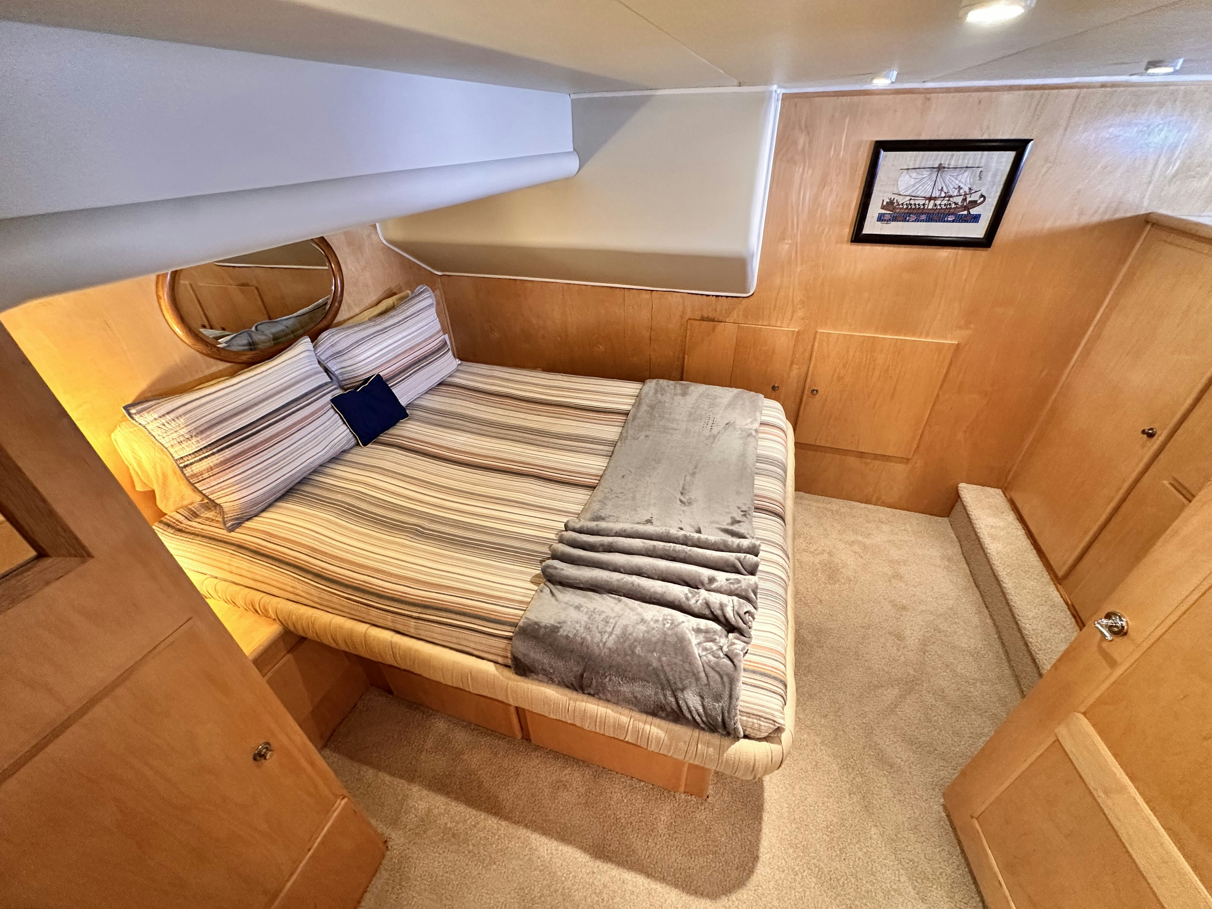 a room with a bed and a wooden floor aboard BARKRUISER Yacht for Sale
