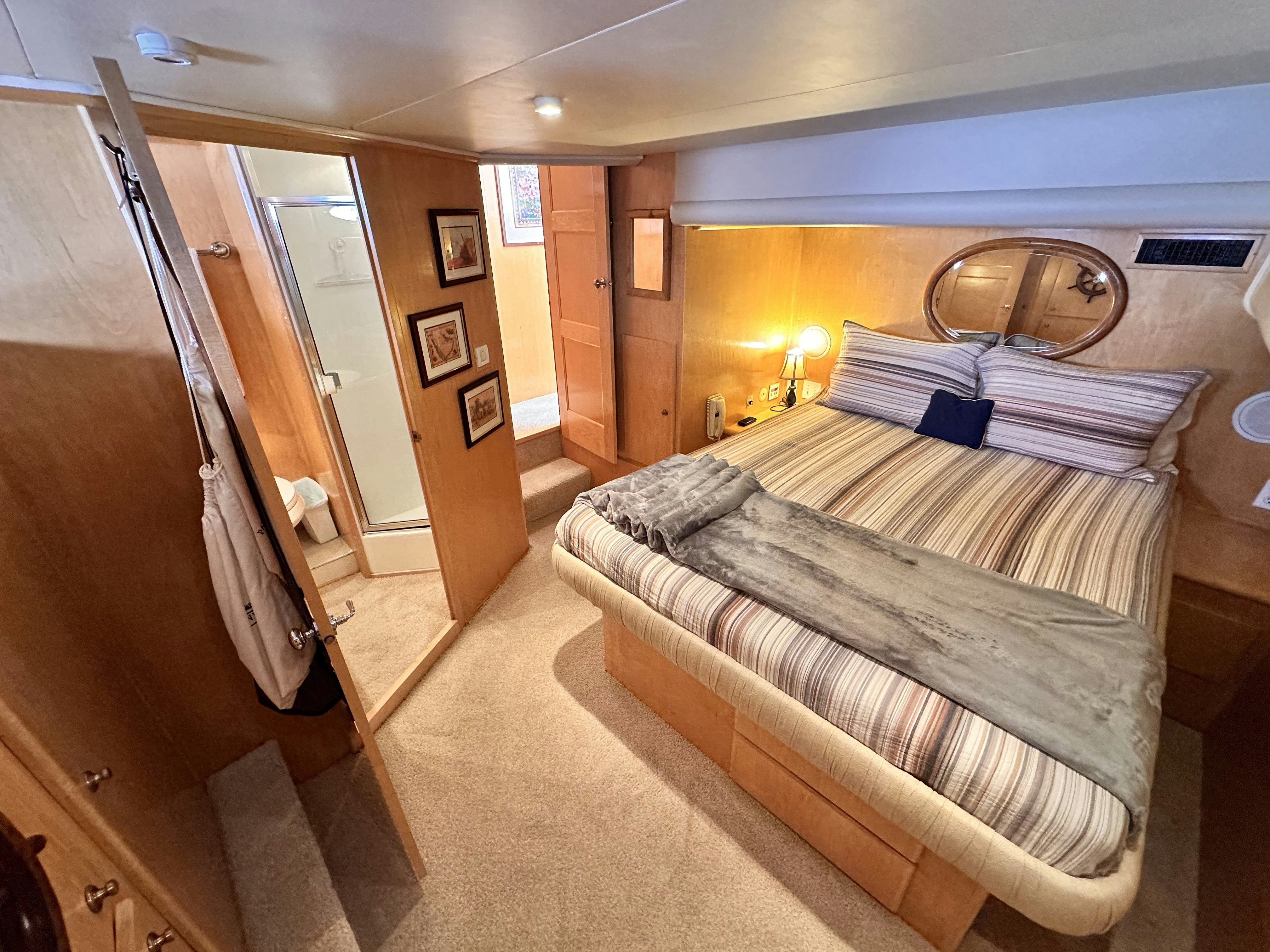 a bedroom with a bed and a mirror aboard BARKRUISER Yacht for Sale