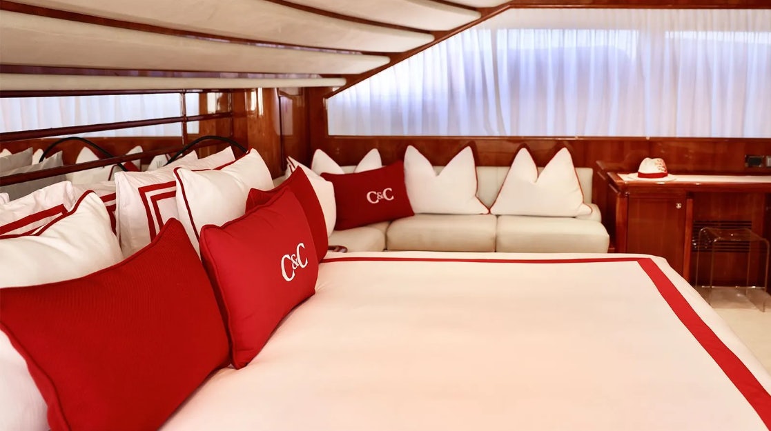 a bed with red pillows aboard CHAMPAGNE & CAVIAR Yacht for Charter