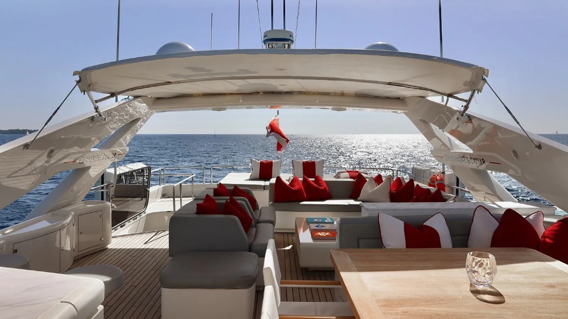 a deck with a view of the ocean and a boat aboard CHAMPAGNE & CAVIAR Yacht for Charter