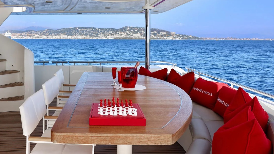 a table with a red and white sign on it on a boat aboard CHAMPAGNE & CAVIAR Yacht for Charter