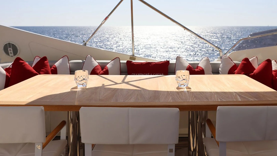 a table with chairs on it aboard CHAMPAGNE & CAVIAR Yacht for Charter