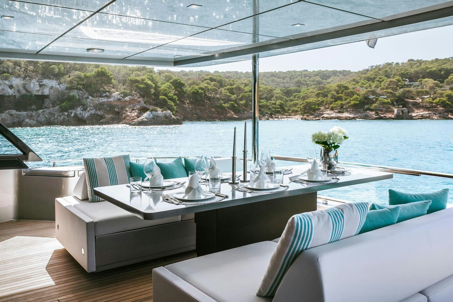 a table with chairs and a view of a lake aboard BARRACUDA III Yacht for Charter
