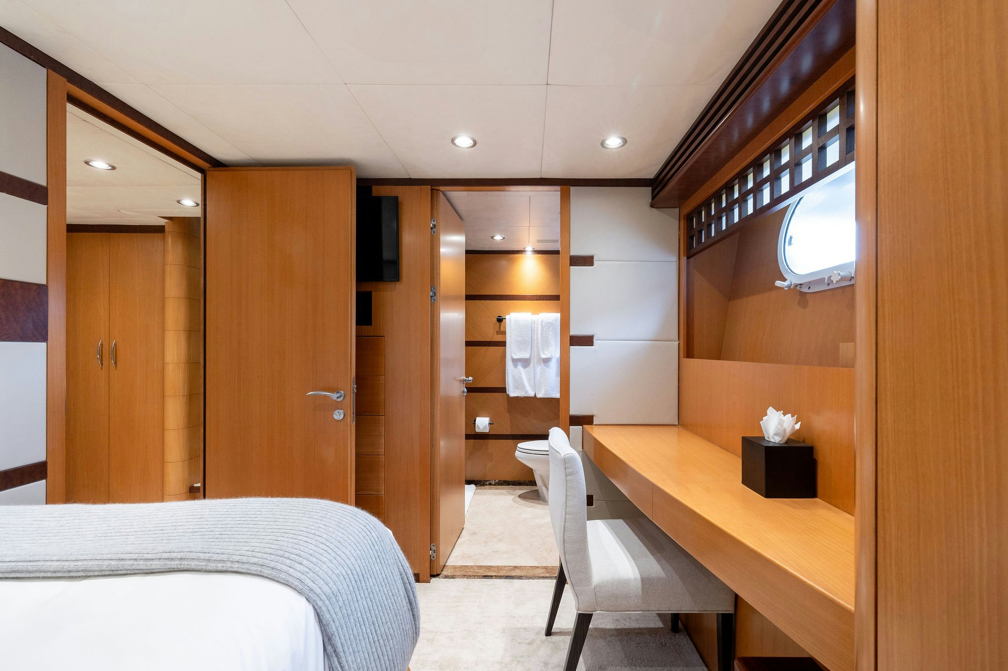 a room with a bed and desk aboard LAST CALL Yacht for Charter