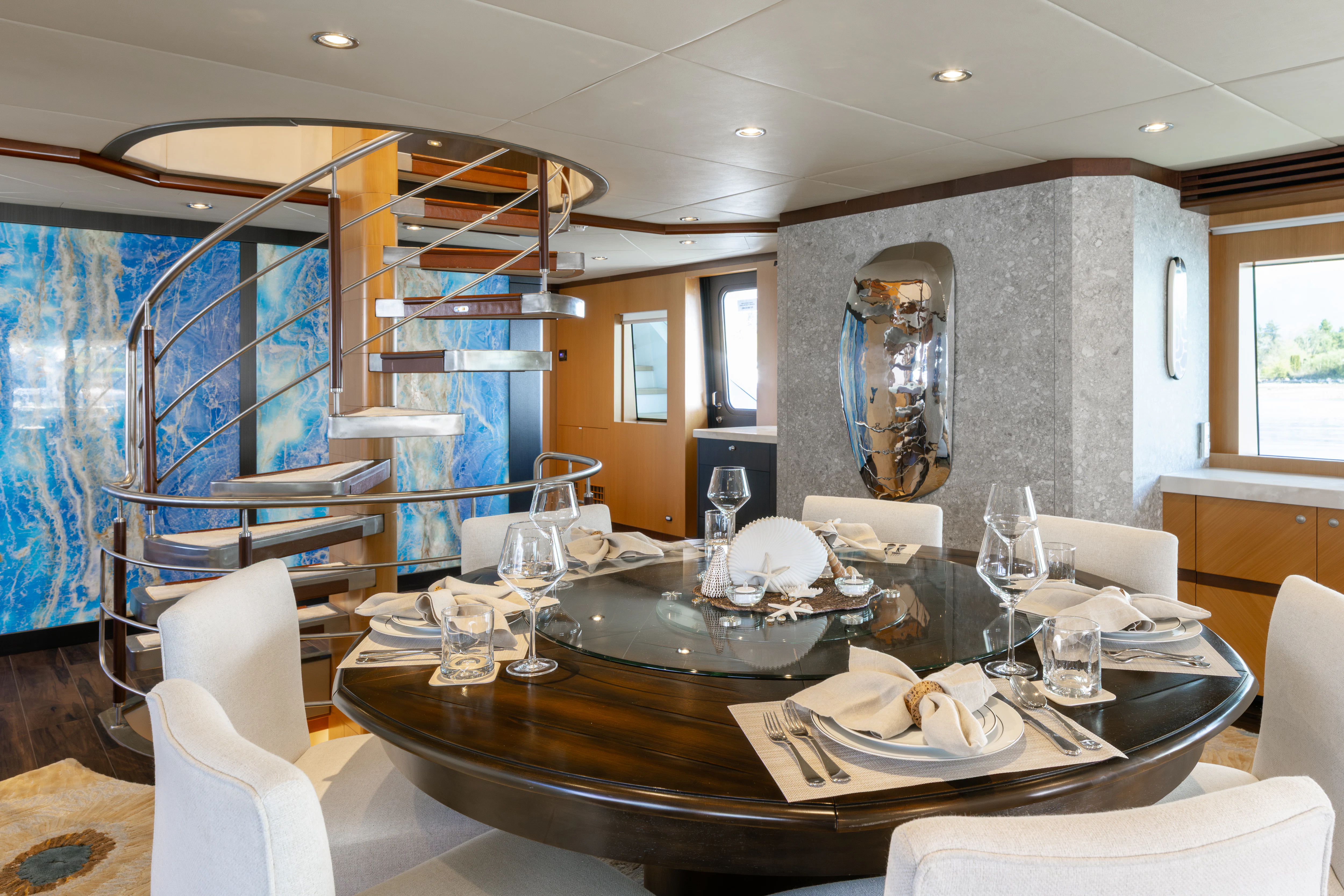 a large dining table with white chairs aboard LAST CALL Yacht for Charter