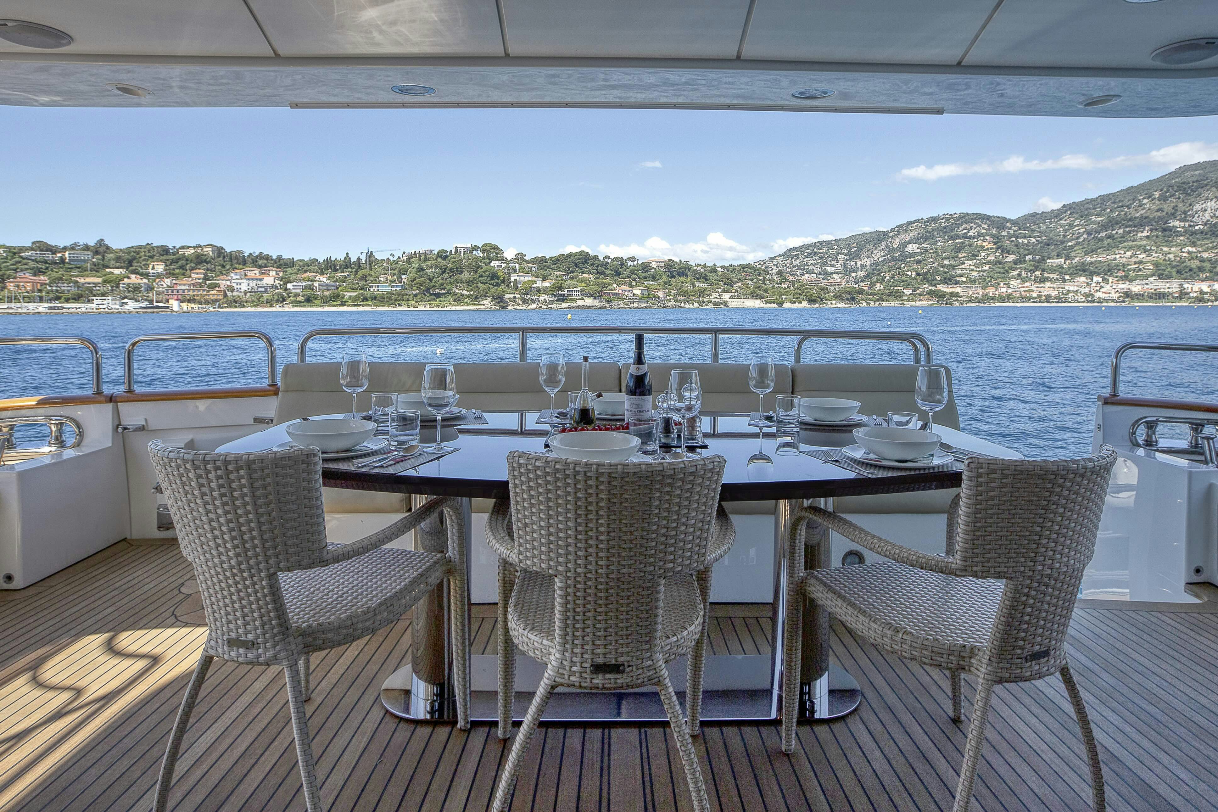 a table set for a meal on a deck overlooking a body of water aboard ROSE OF KINGSTON II Yacht for Sale