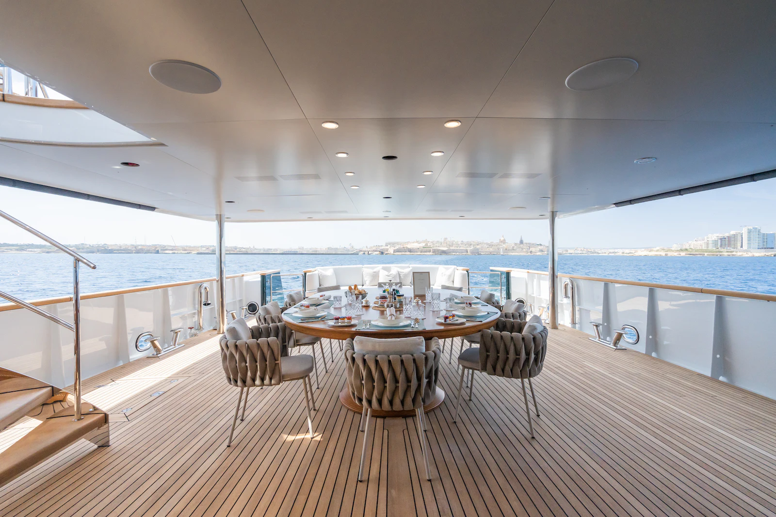a table with chairs on a deck overlooking a body of water aboard EMERALD Yacht for Charter