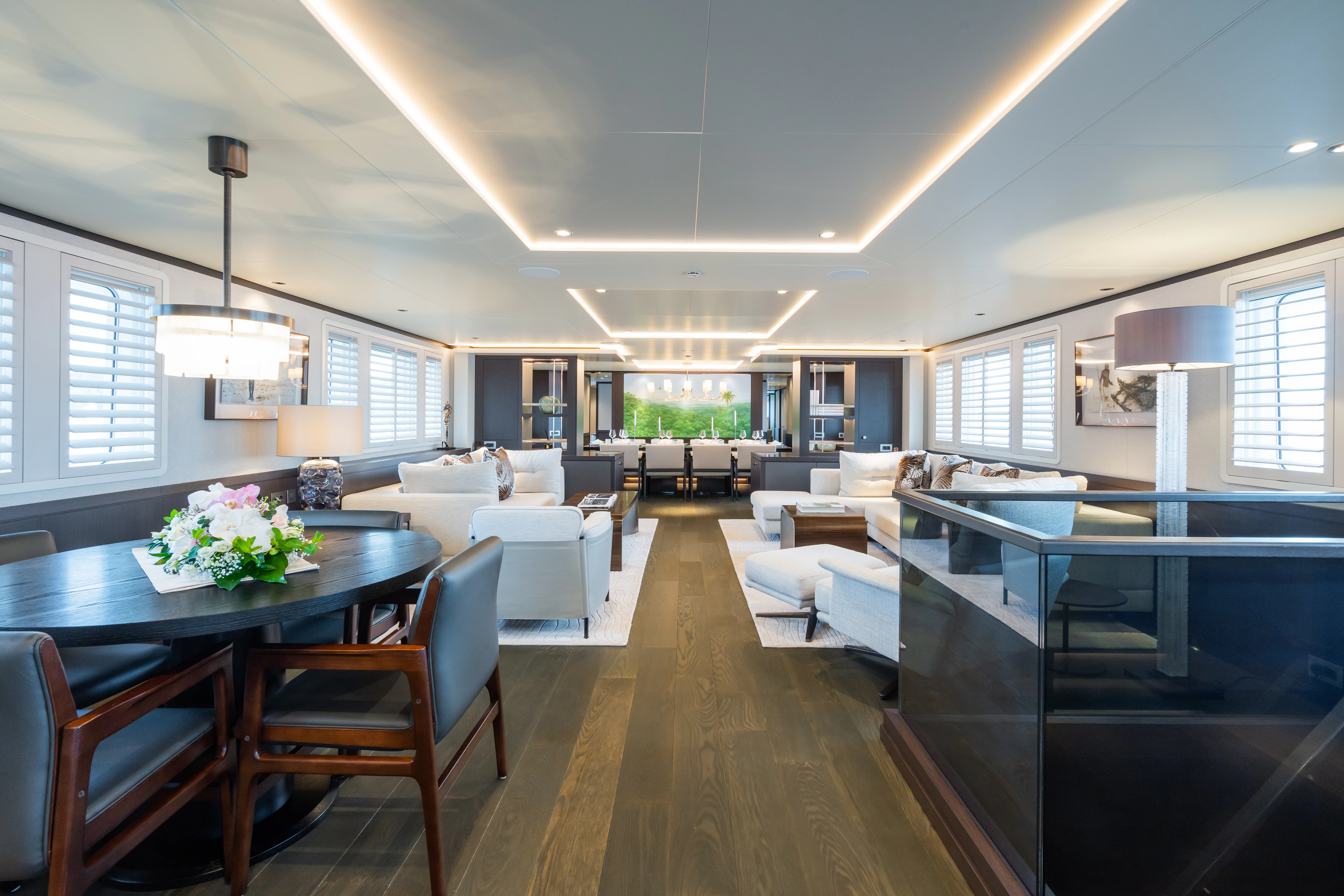 a large living room with a dining table and a large window aboard EMERALD Yacht for Charter
