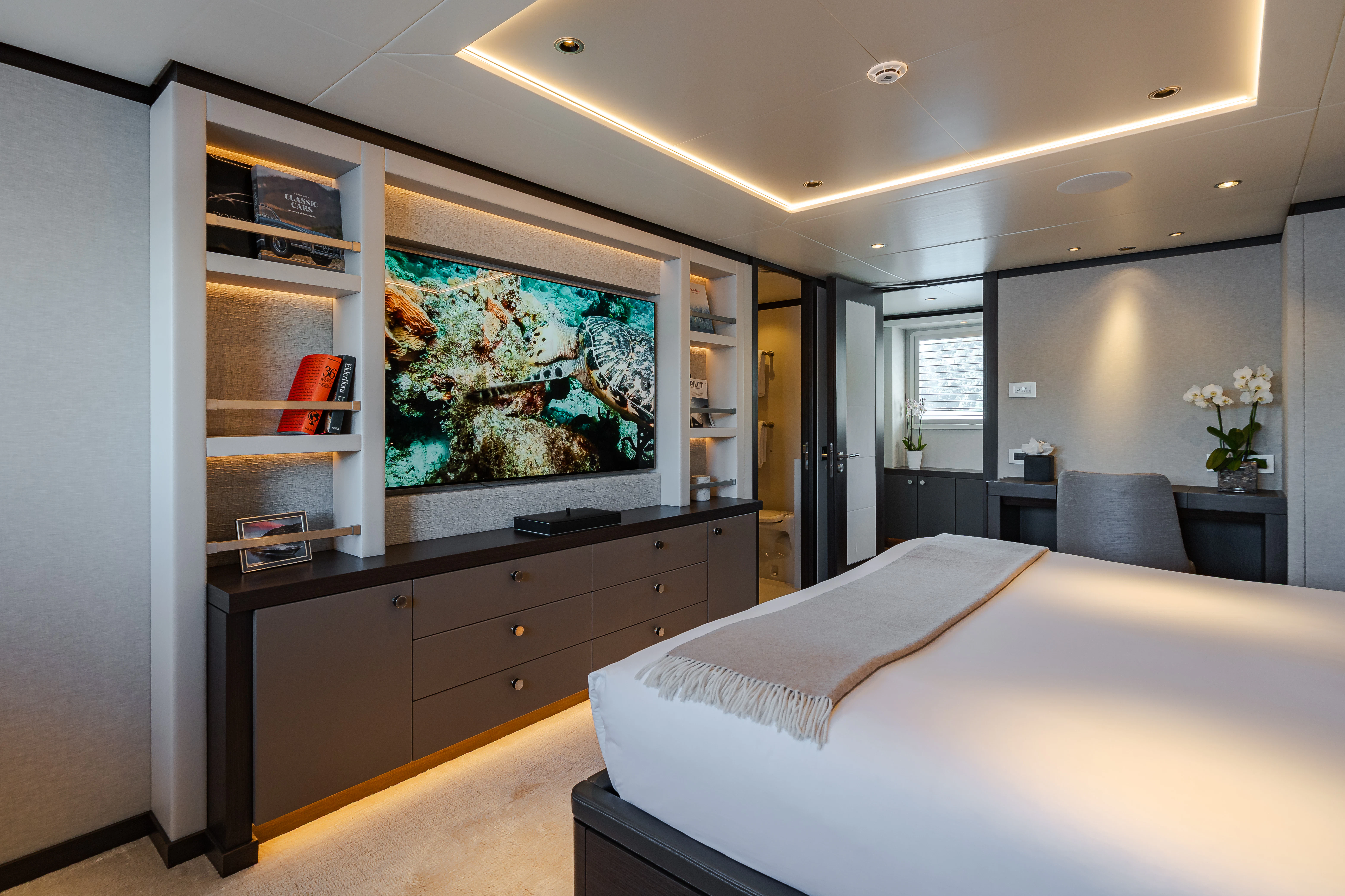 a bedroom with a large bed and a large television aboard EMERALD Yacht for Sale