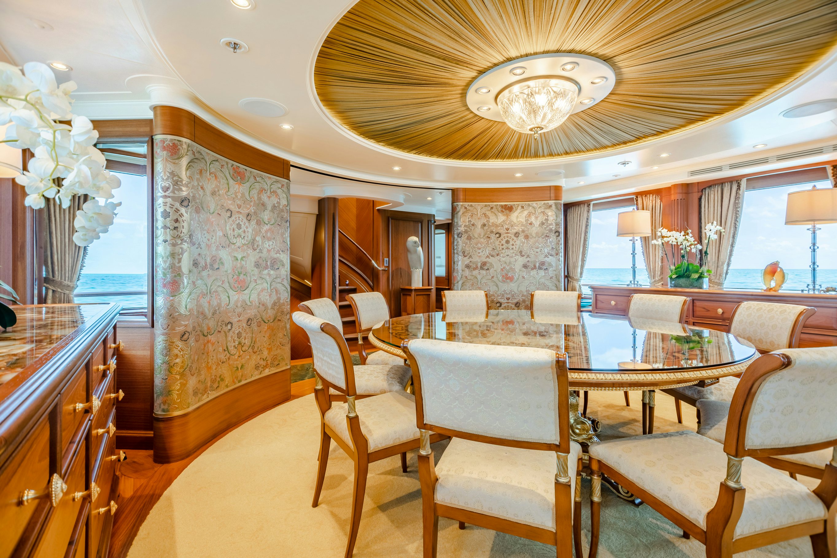 a large room with chairs and a chandelier aboard SHADOWL Yacht for Sale