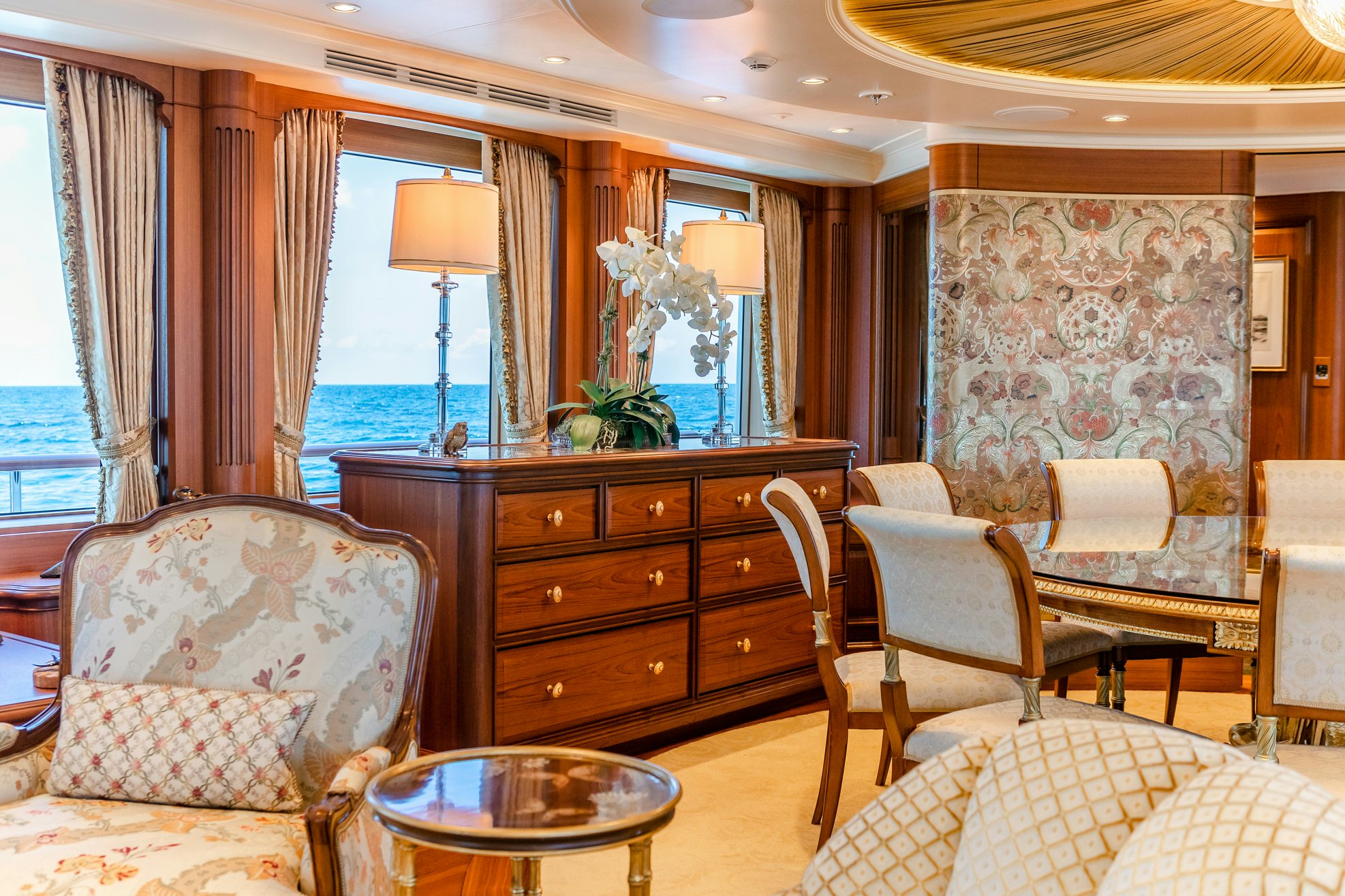 a living room with a dresser and a chair aboard SHADOWL Yacht for Charter