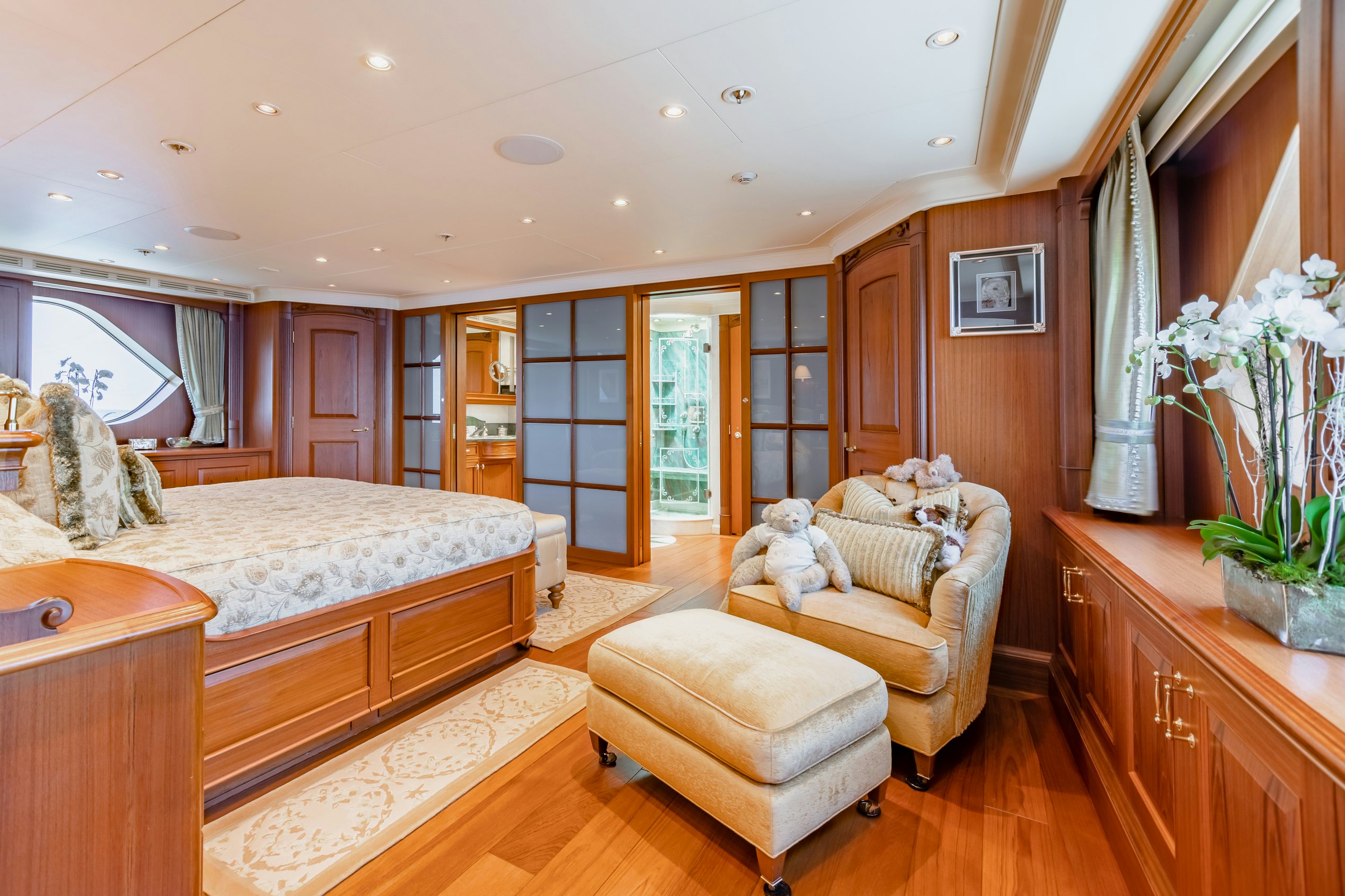 a bedroom with a bed and a chair aboard SHADOWL Yacht for Charter